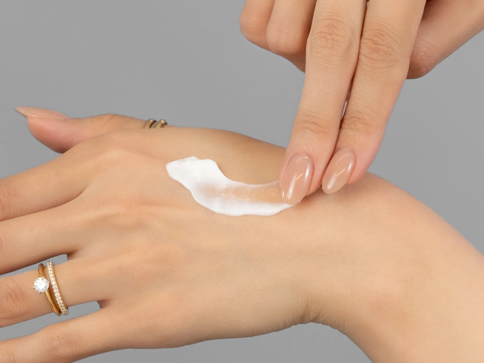 Laziza from LAZ Skincare demonstrating the texture and application of Environ Defence Creme on her hand