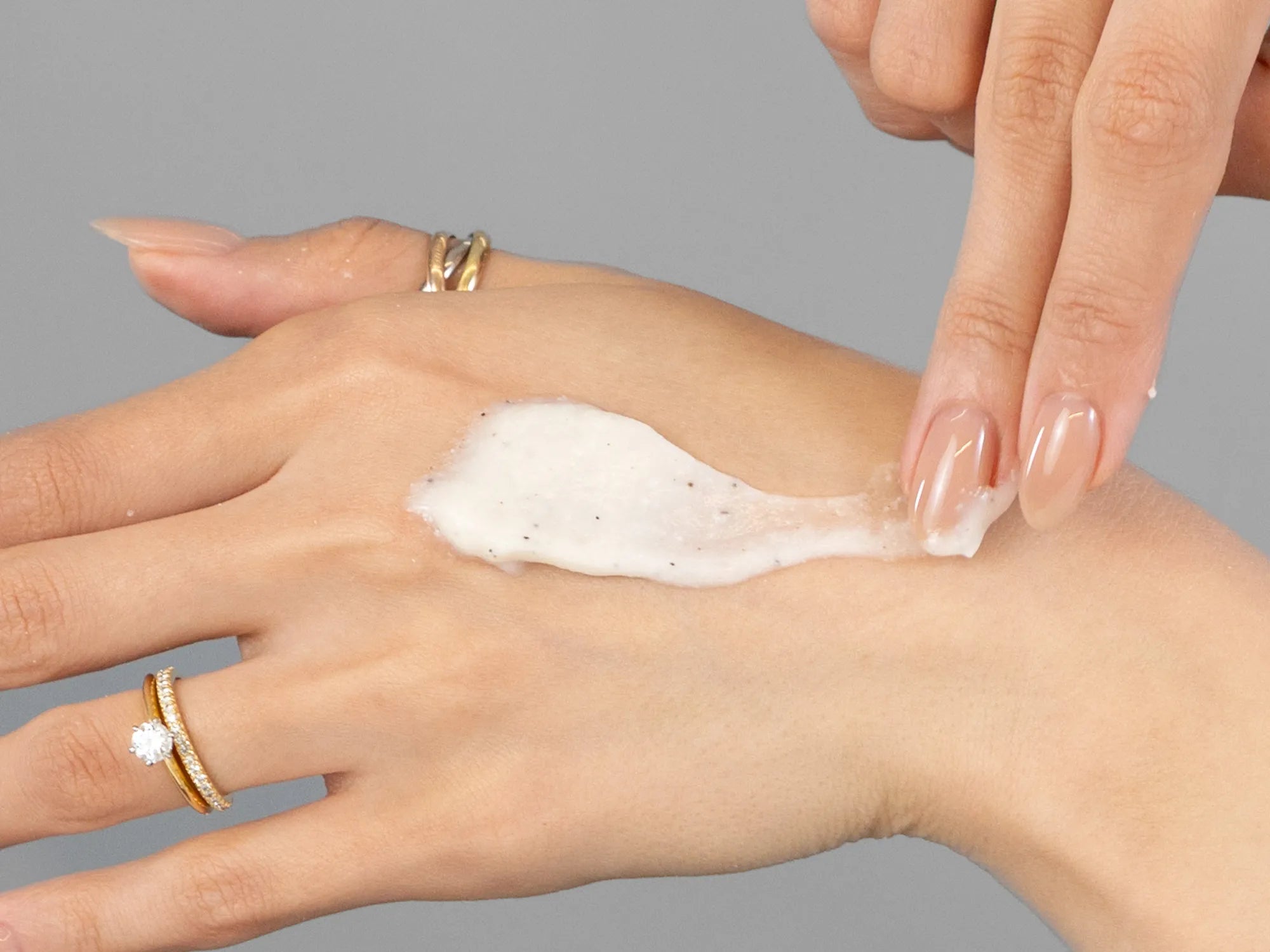 Laziza from LAZ Skincare demonstrating the texture and application of Epicuren Papaya Pineapple Bamboo Body Polish on her hand