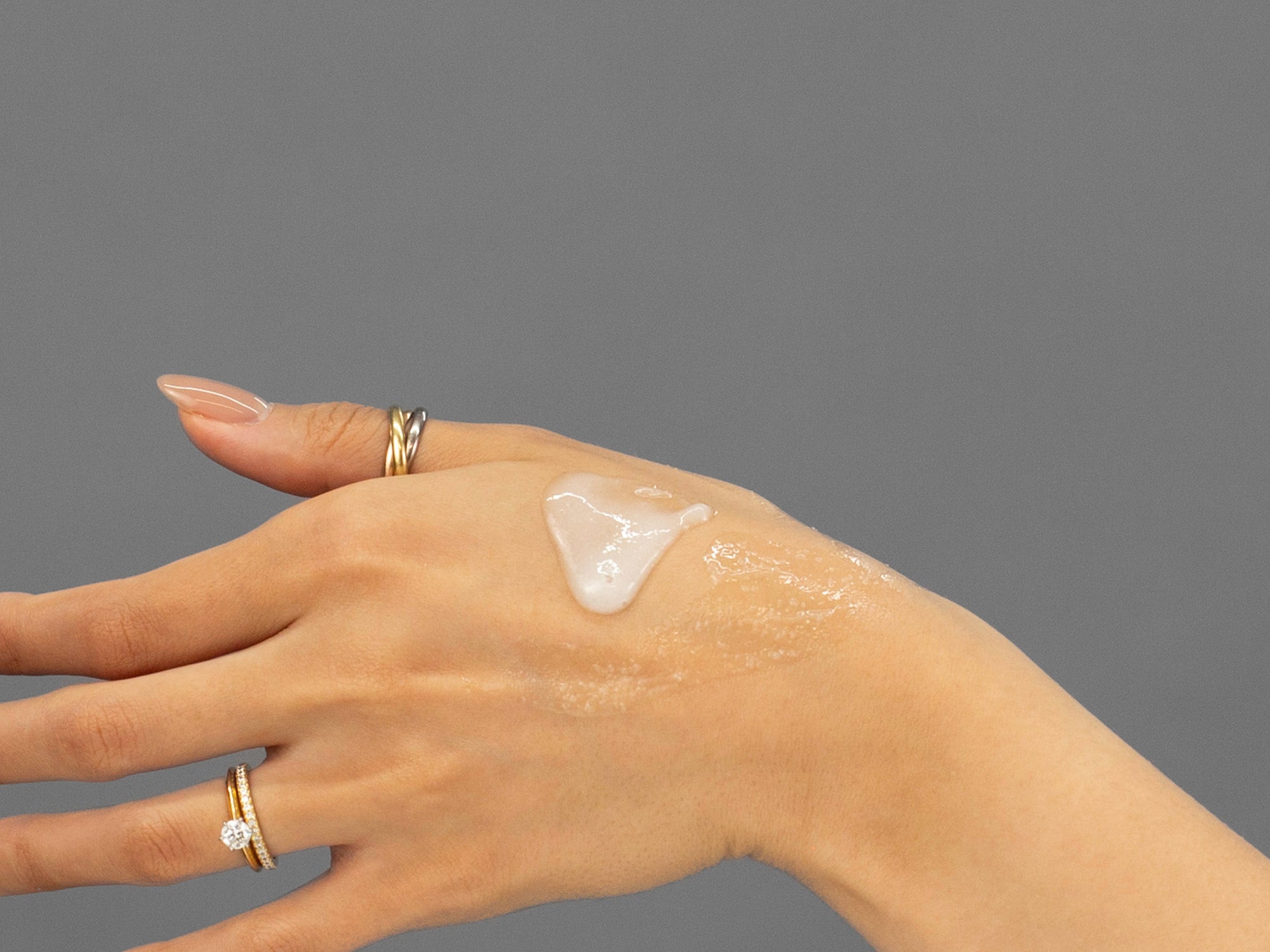 Closeup of Laziza from LAZ Skincare applying Face Reality Acne Face & Body Scrub to her hand