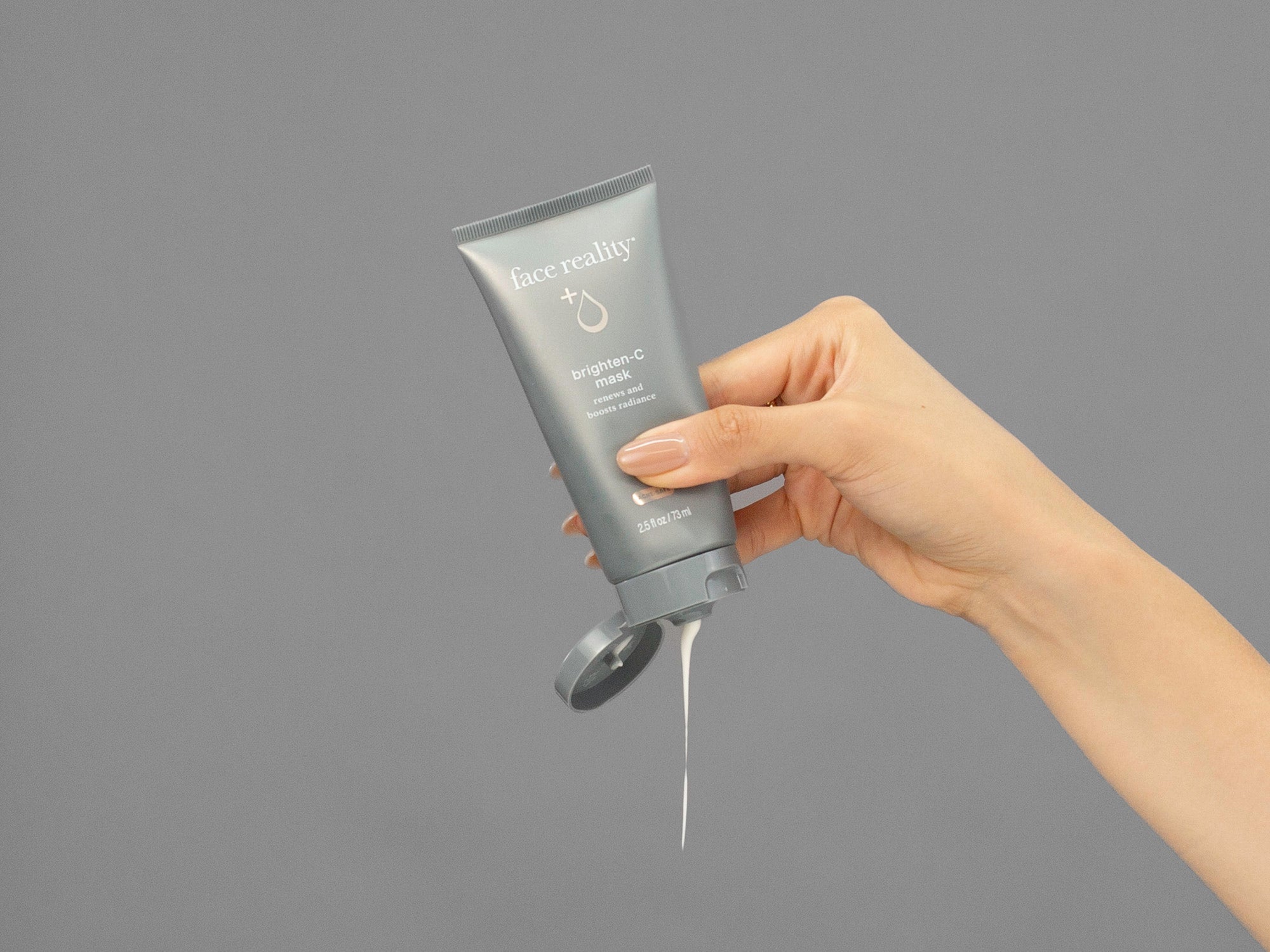 Closeup of Laziza from LAZ Skincare squeezing a tube of Face Reality Brighten-C Mask