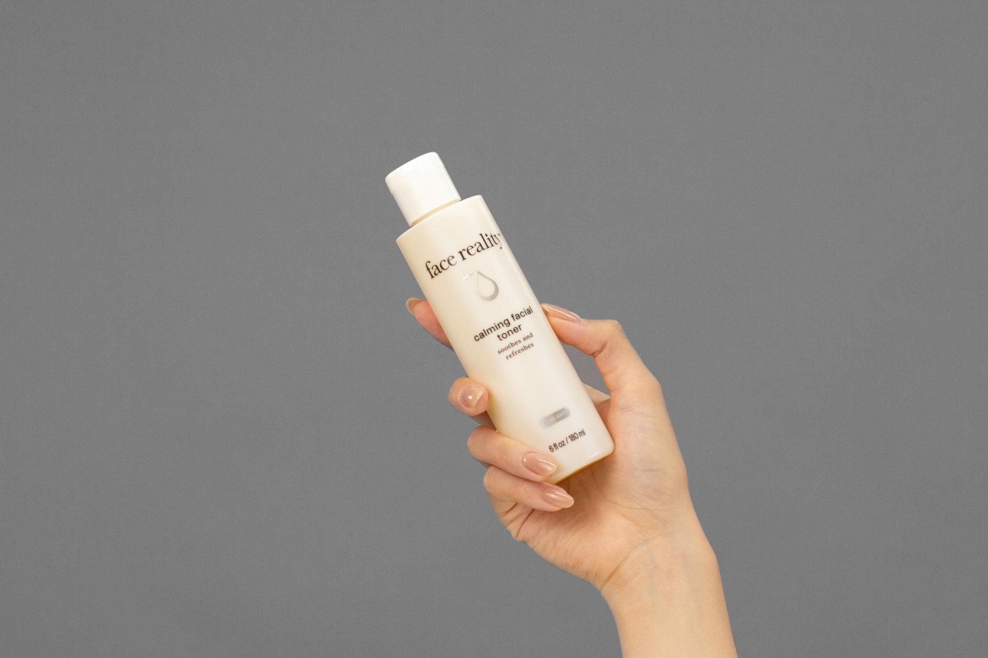 Closeup of Laziza from LAZ Skincare holding a bottle of Face Reality Calming Facial Toner in her hand