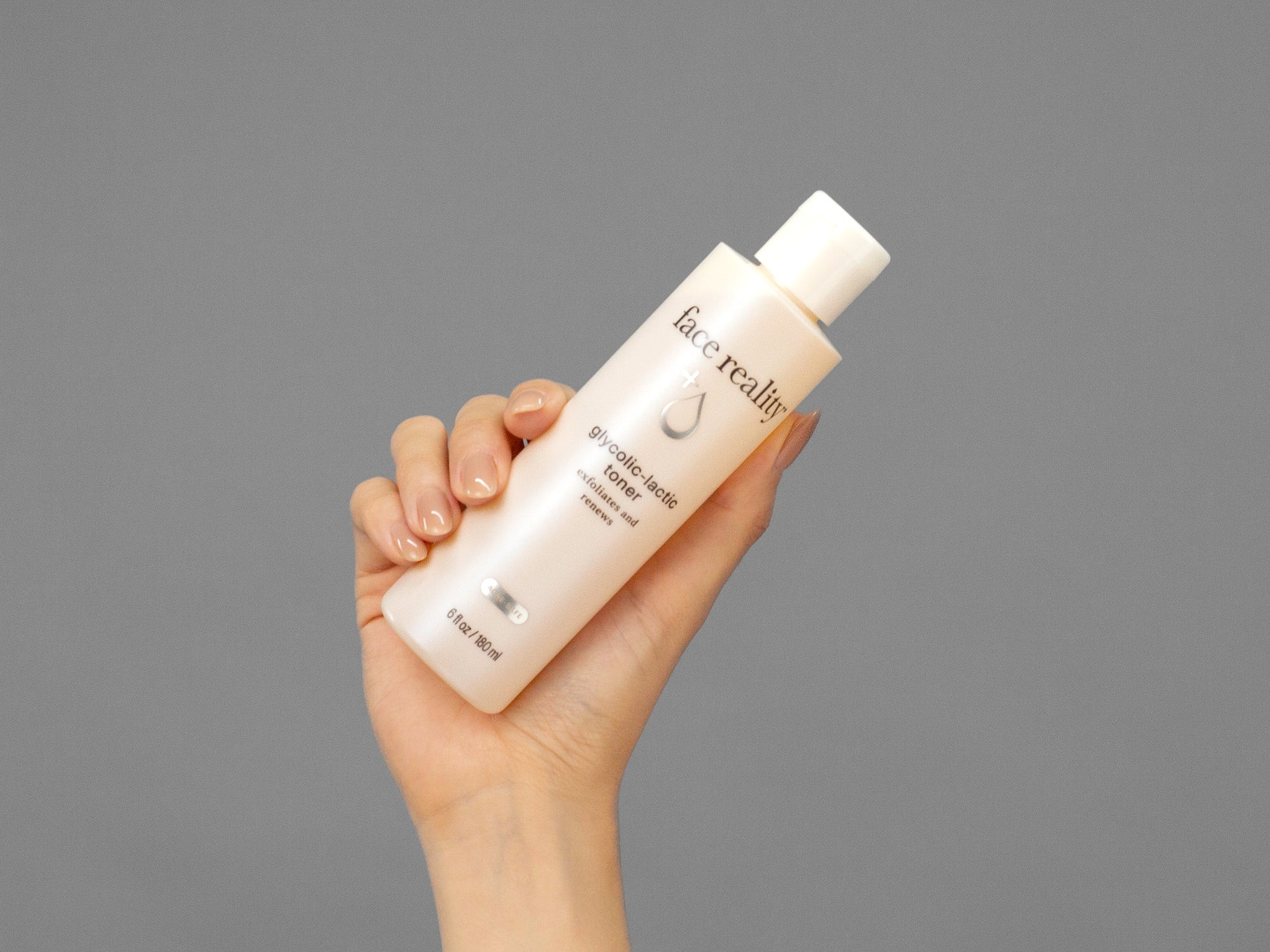 Closeup of Laziza from LAZ Skincare holding up a bottle of Face Reality Glycolic-Lactic Toner in her hand