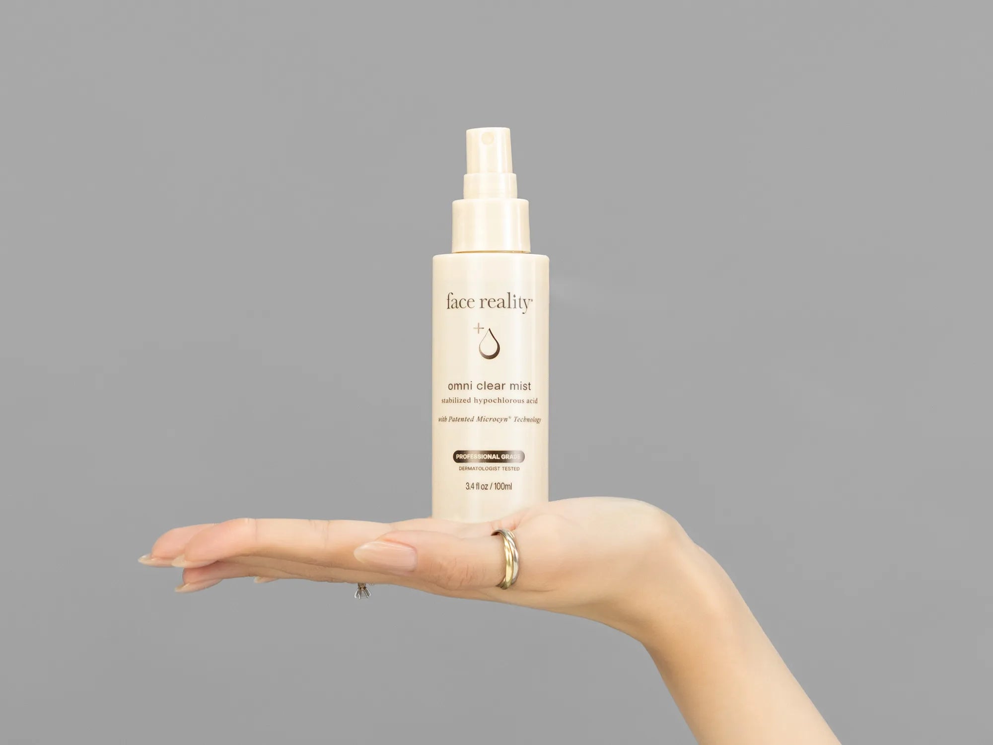 Closeup of Laziza from LAZ Skincare holding up a bottle of Face Reality Omni Clear Mist