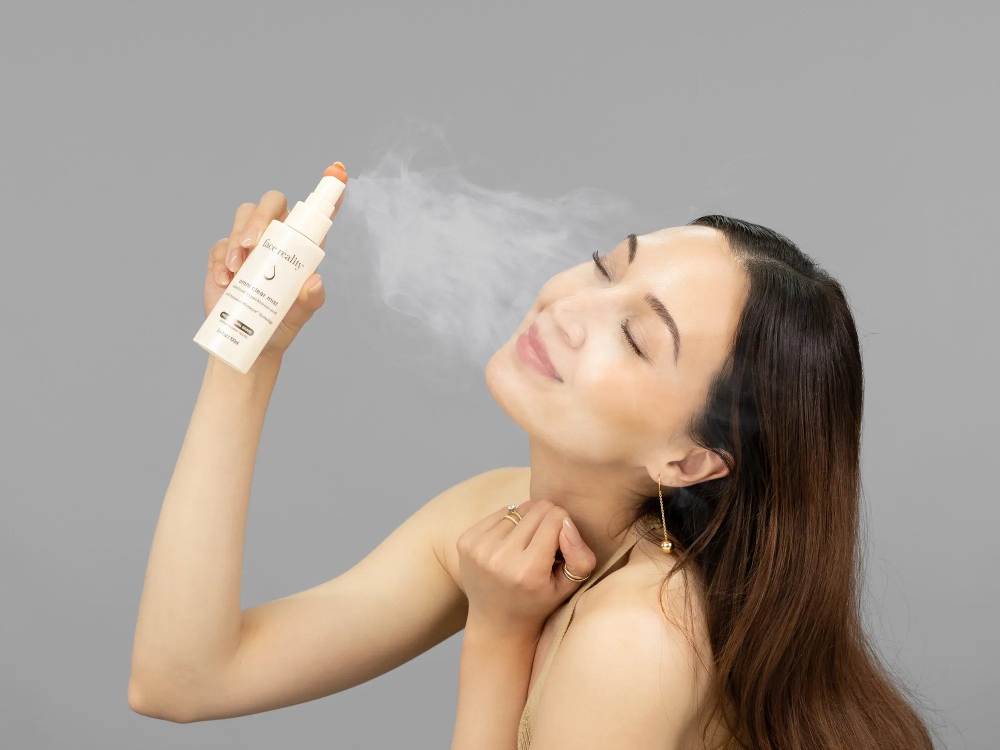 Laziza from LAZ Skincare demonstrating the texture and application of Face Reality Omni Clear Mist on her hand