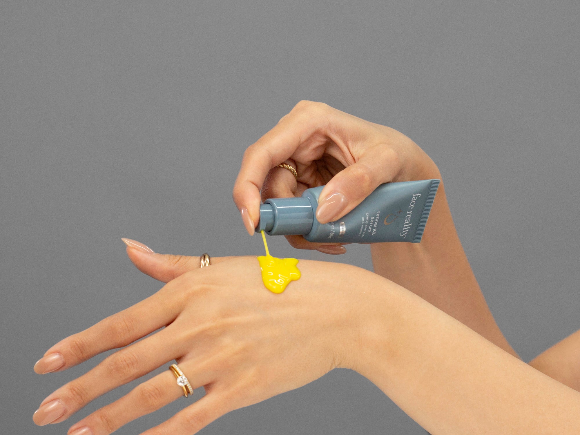 Closeup of Laziza from LAZ Skincare applying Face Reality Retinal B3 Serum to her hand