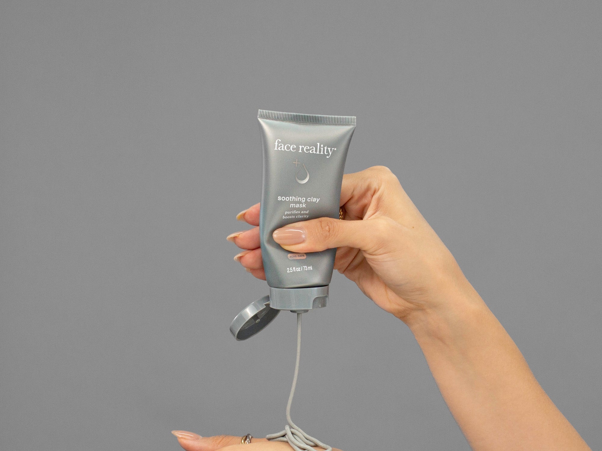 Closeup of Laziza from LAZ Skincare squeezing a tube of Face Reality Soothing Clay Mask