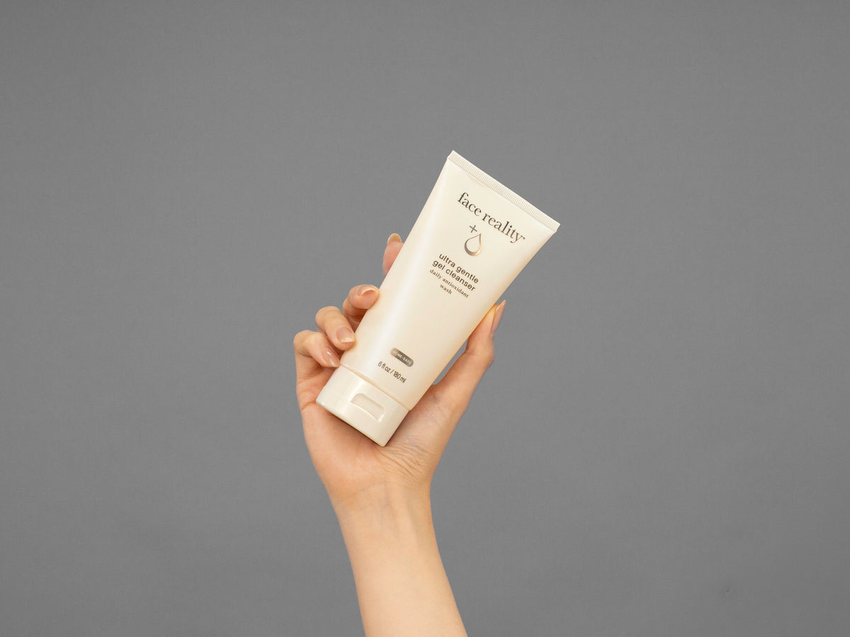 Closeup of Laziza from LAZ Skincare holding up a bottle of Face Reality Ultra Gentle Gel Cleanser