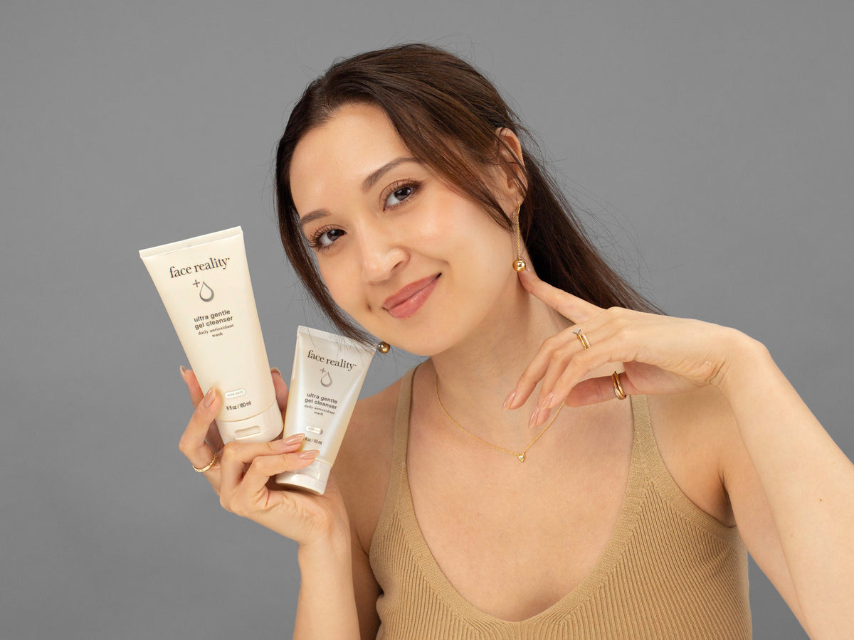 Laziza from LAZ Skincare holding a bottle of Face Reality Ultra Gentle Gel Cleanser up to her face