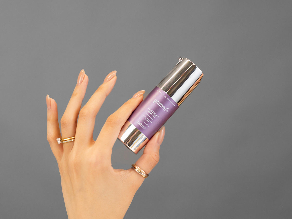 Closeup of Laziza from LAZ Skincare holding up a bottle of GlyMed Age Delay Cream