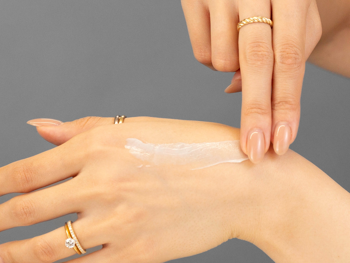 Laziza from LAZ Skincare demonstrating the texture and application of GlyMed Age Delay Cream on her hand