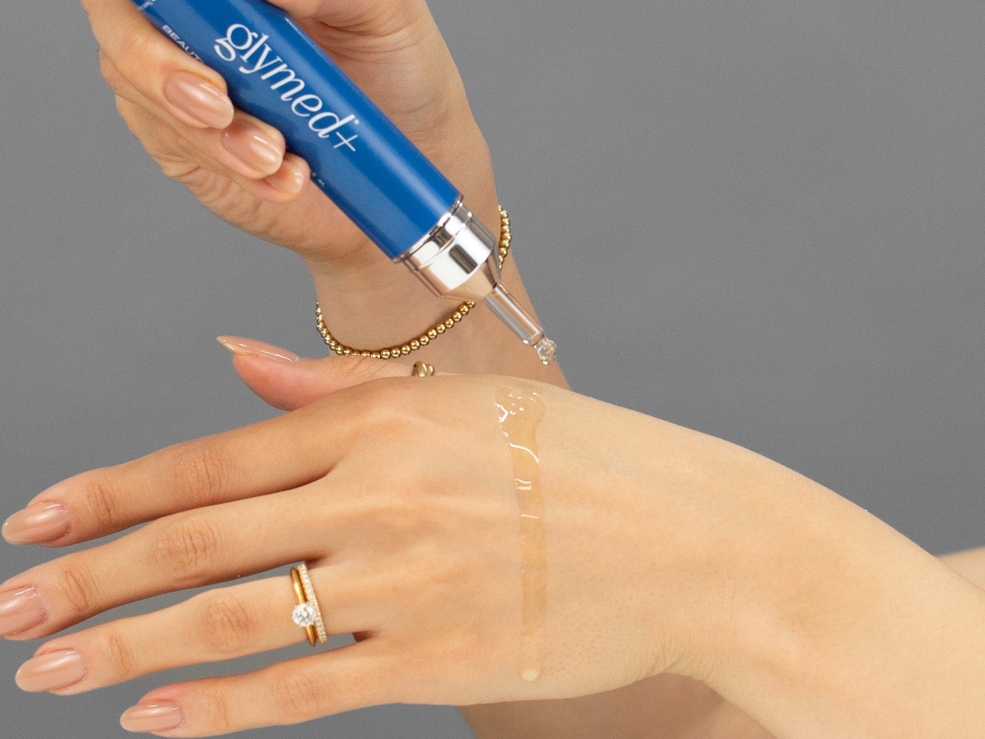 Closeup of Laziza from LAZ Skincare applying GlyMed Beauty Oil to her hand