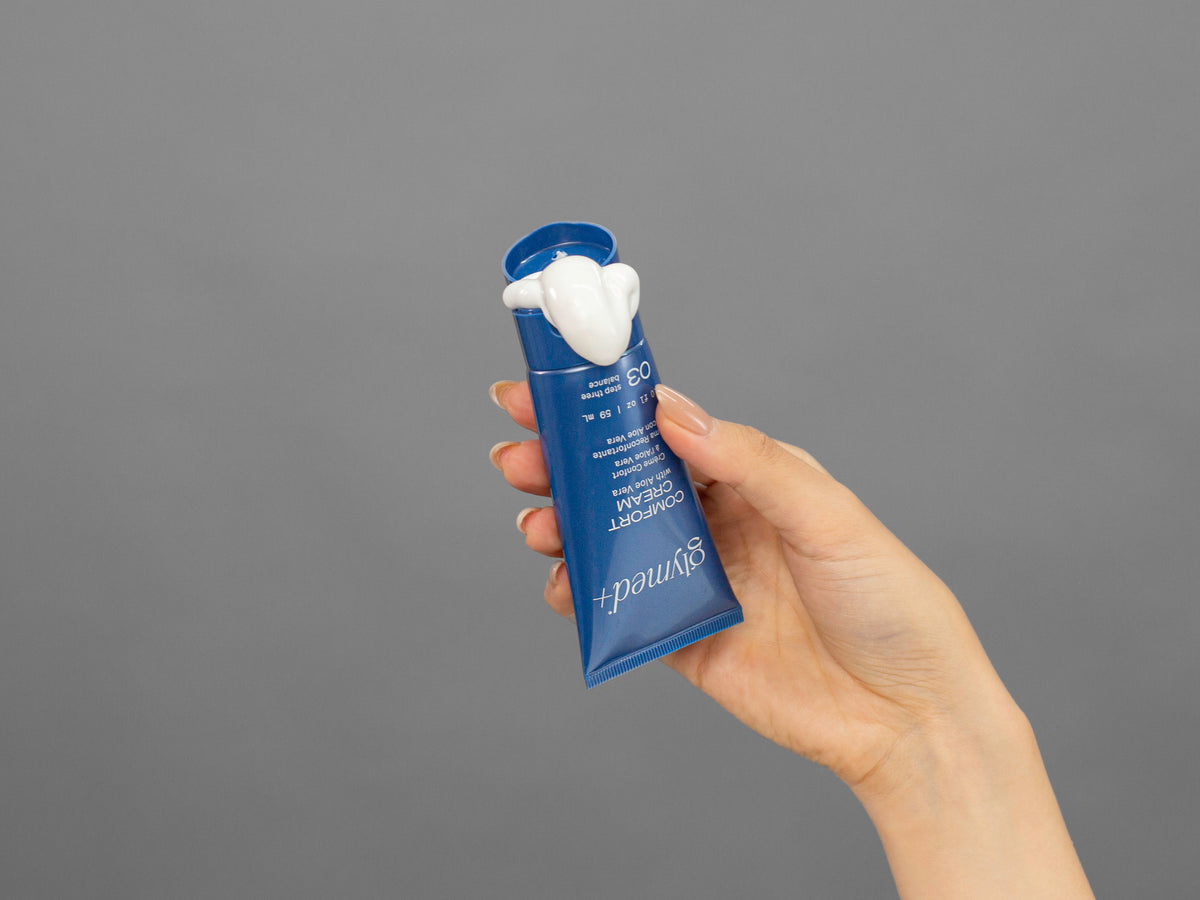 Closeup of Laziza from LAZ Skincare holding up a bottle of GlyMed Comfort Cream
