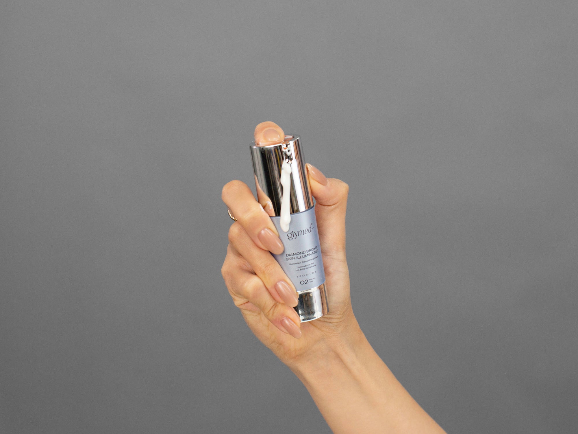 Closeup of Laziza from LAZ Skincare holding a bottle of GlyMed Diamond Bright Skin Illuminator in her hand