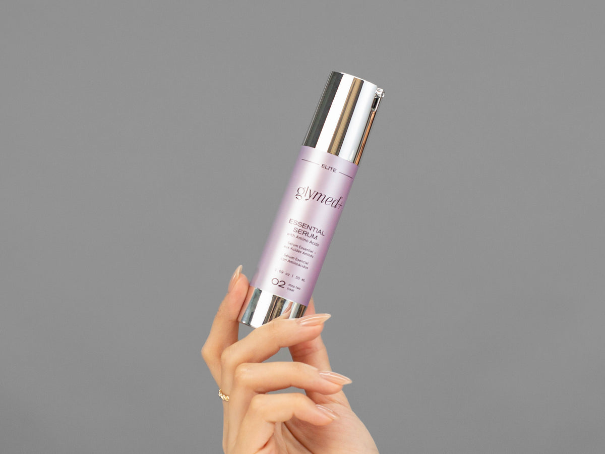 Closeup of Laziza from LAZ Skincare holding up a bottle of GlyMed Essential Serum