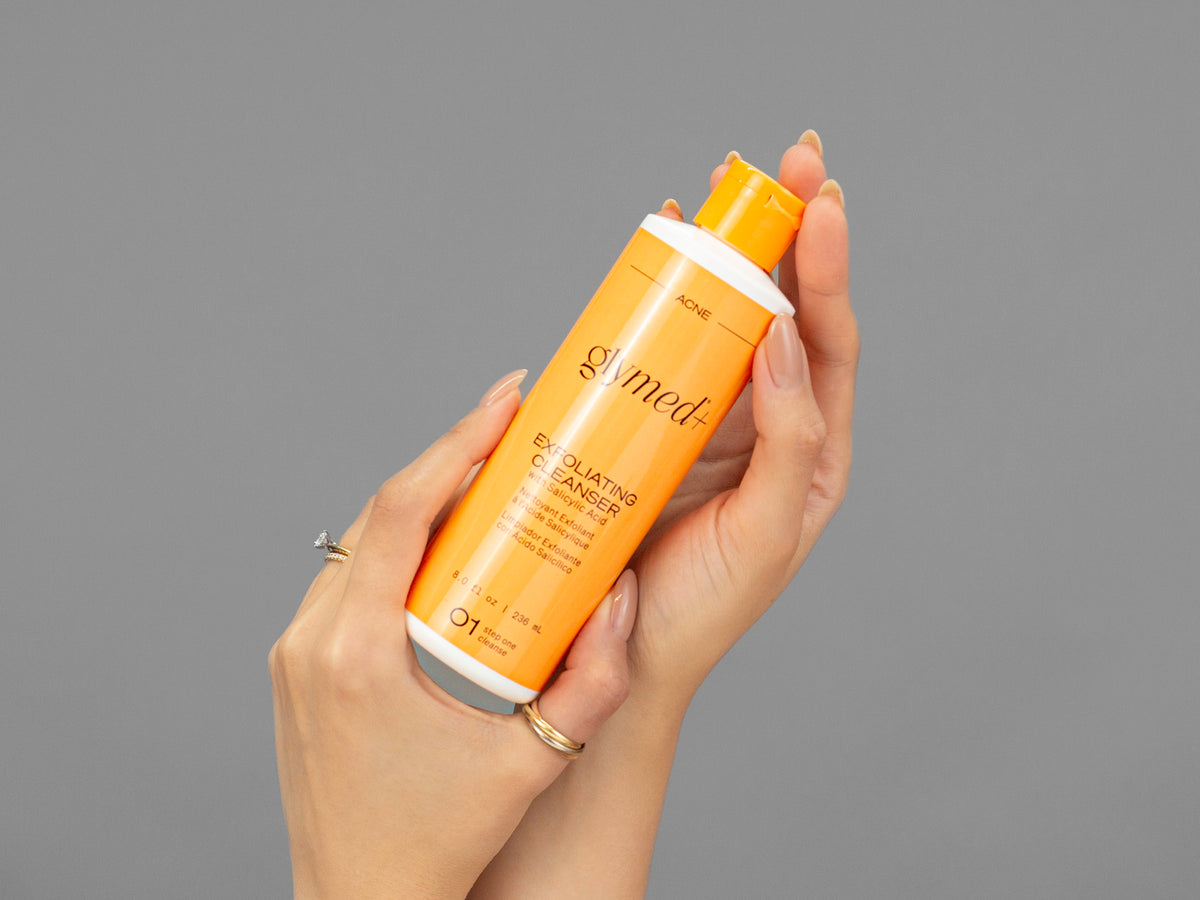 Closeup of Laziza from LAZ Skincare holding up a bottle of GlyMed Exfoliating Cleanser