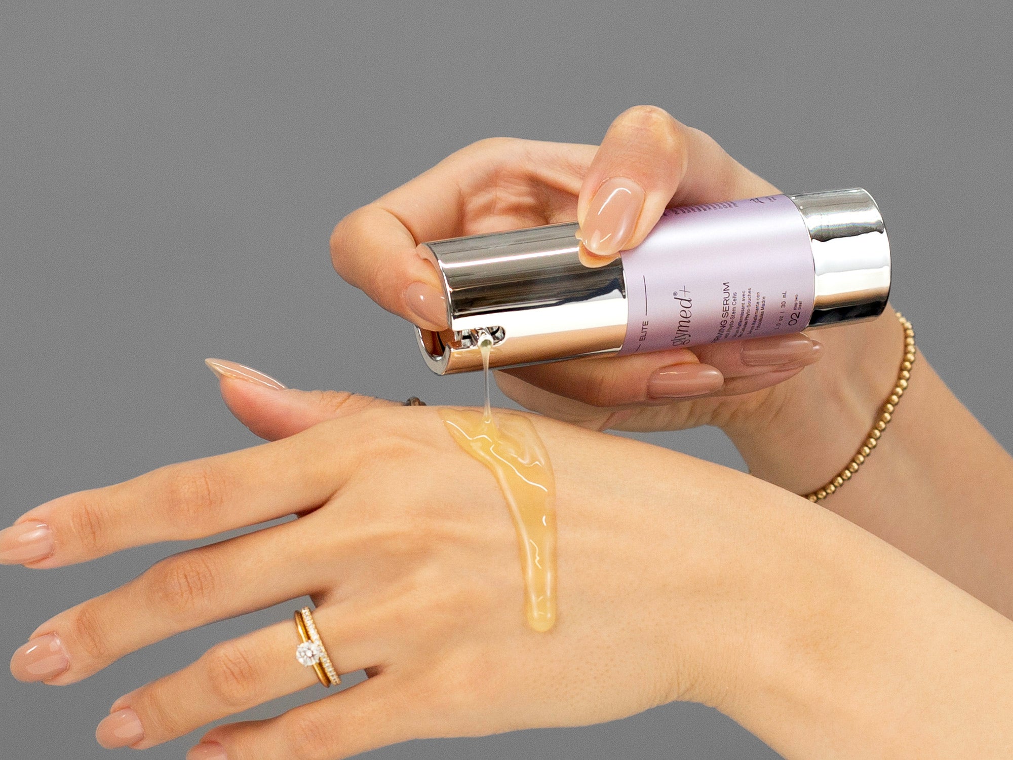 Closeup of Laziza from LAZ Skincare applying GlyMed Firming Serum to her hand