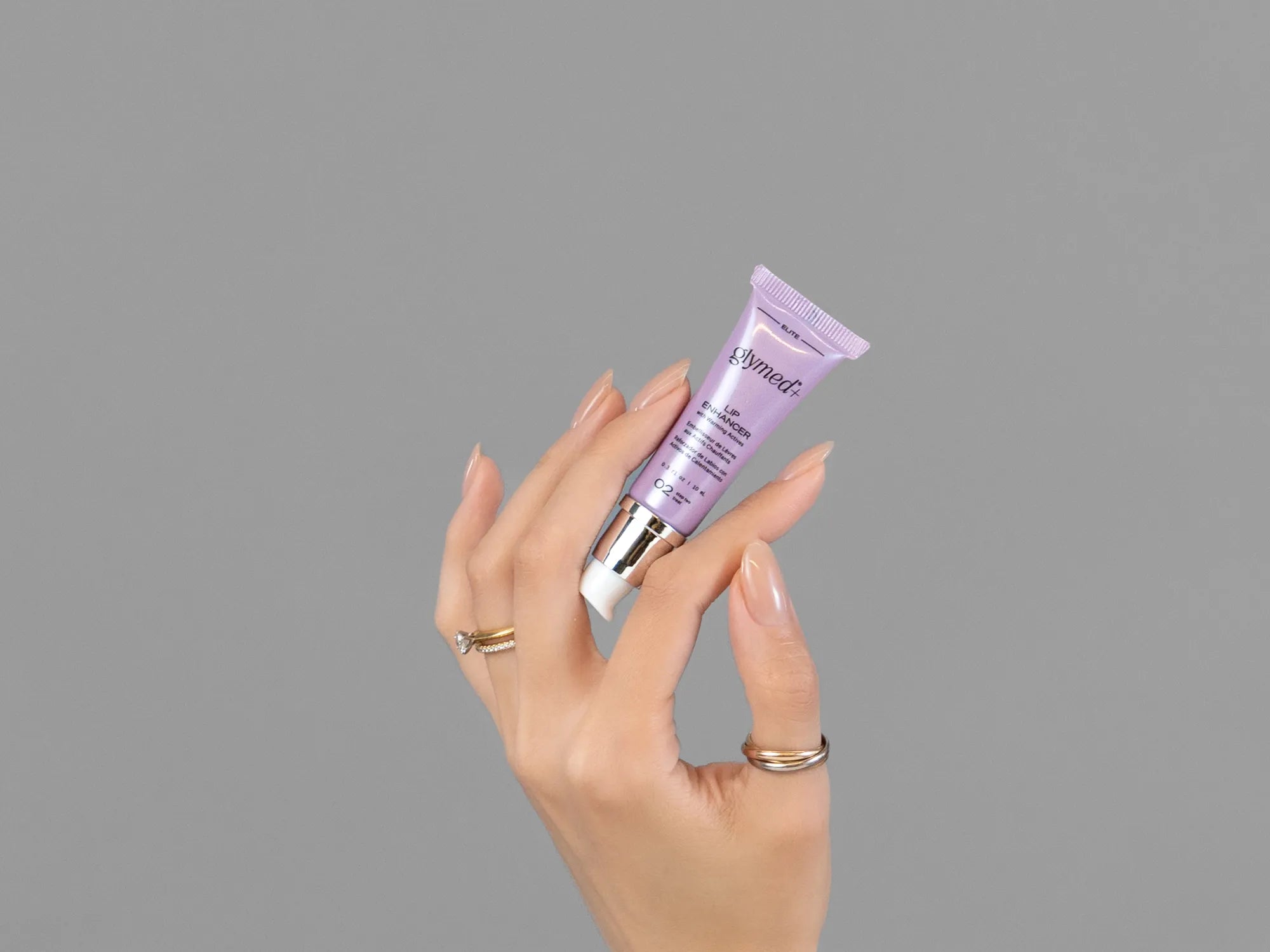 Closeup of Laziza from LAZ Skincare holding up a bottle of GlyMed Lip Enhancer