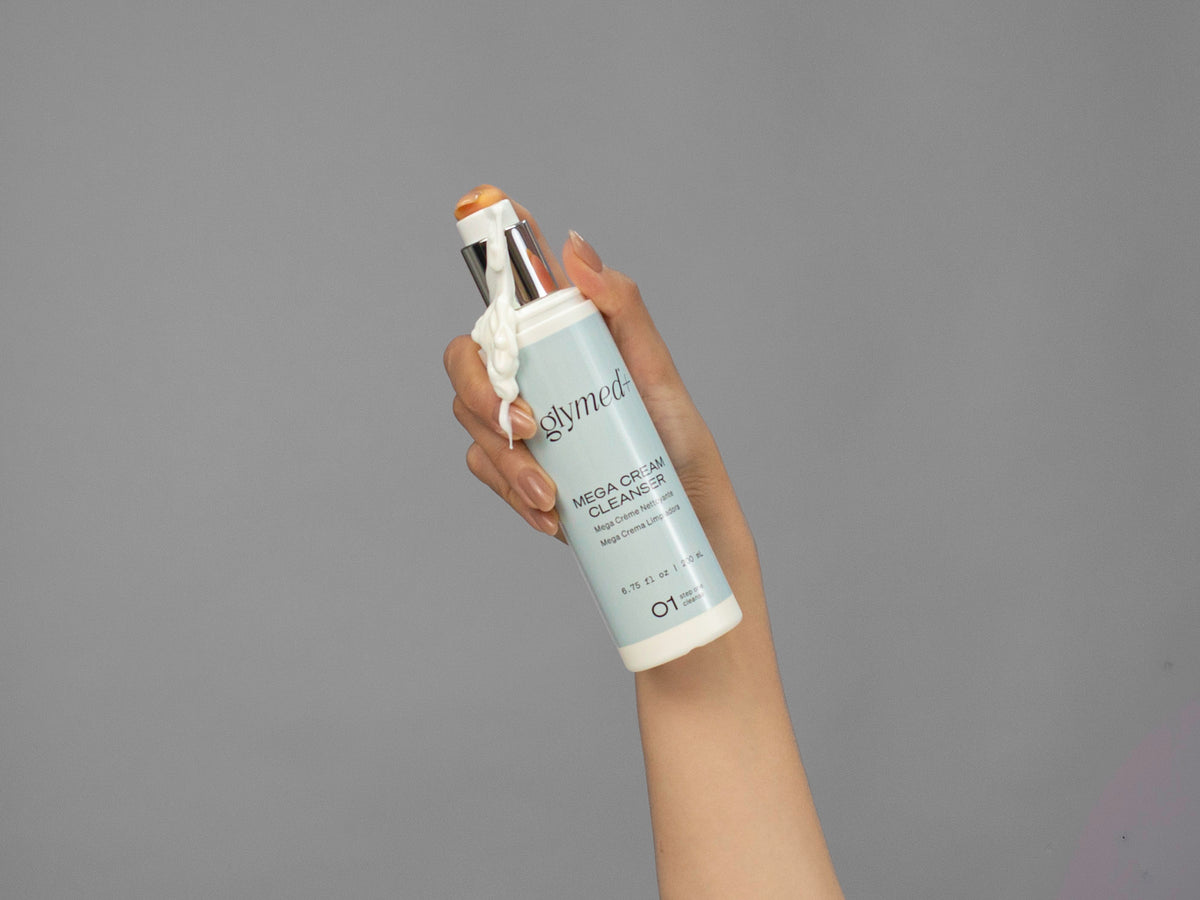 Closeup of Laziza from LAZ Skincare holding up a bottle of GlyMed Mega Cream Cleanser
