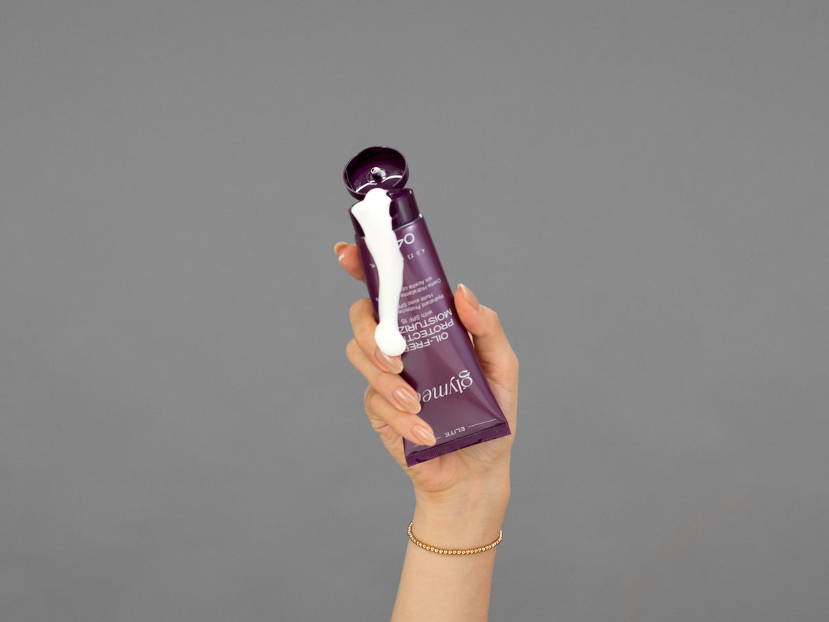 Closeup of Laziza from LAZ Skincare holding up a bottle of GlyMed Oil-Free Protective Moisturizer SPF 15