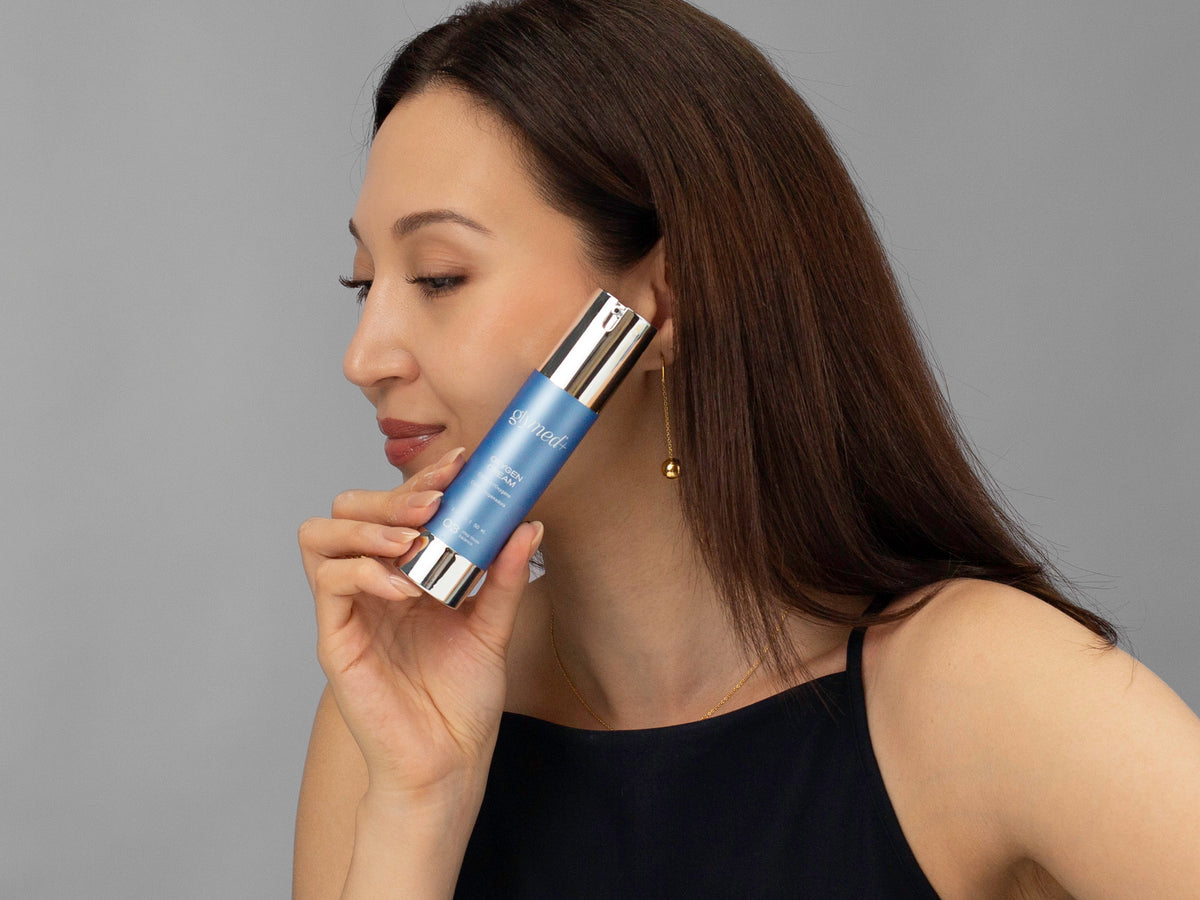 Laziza from LAZ Skincare holding a bottle of GlyMed Oxygen Cream up to her face