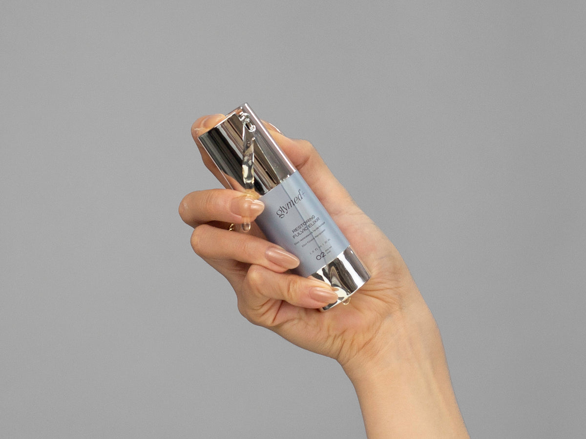 Closeup of Laziza from LAZ Skincare holding up a bottle of GlyMed Restoring Fulvic Elixir