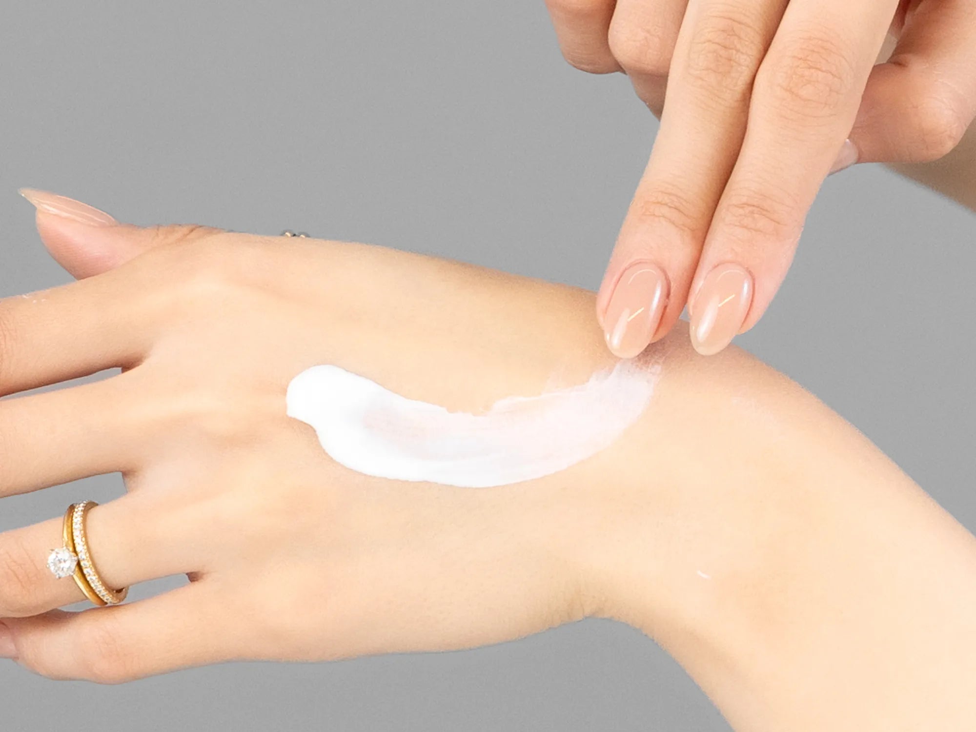 Laziza from LAZ Skincare demonstrating the texture and application of Hale & Hush Broad Spectrum Natural SPF30 on her hand