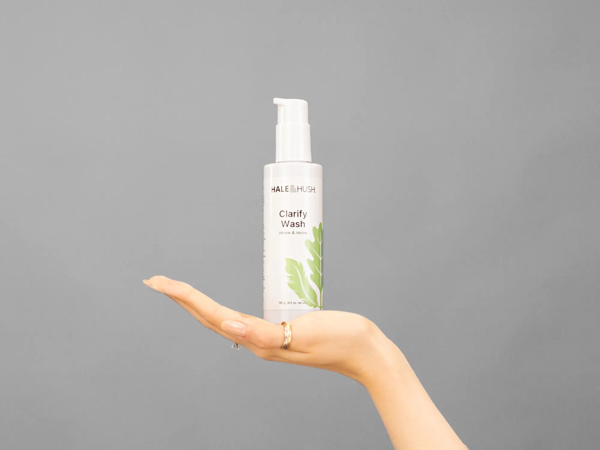 Closeup of Laziza from LAZ Skincare holding up a bottle of Hale & Hush Clarify Wash