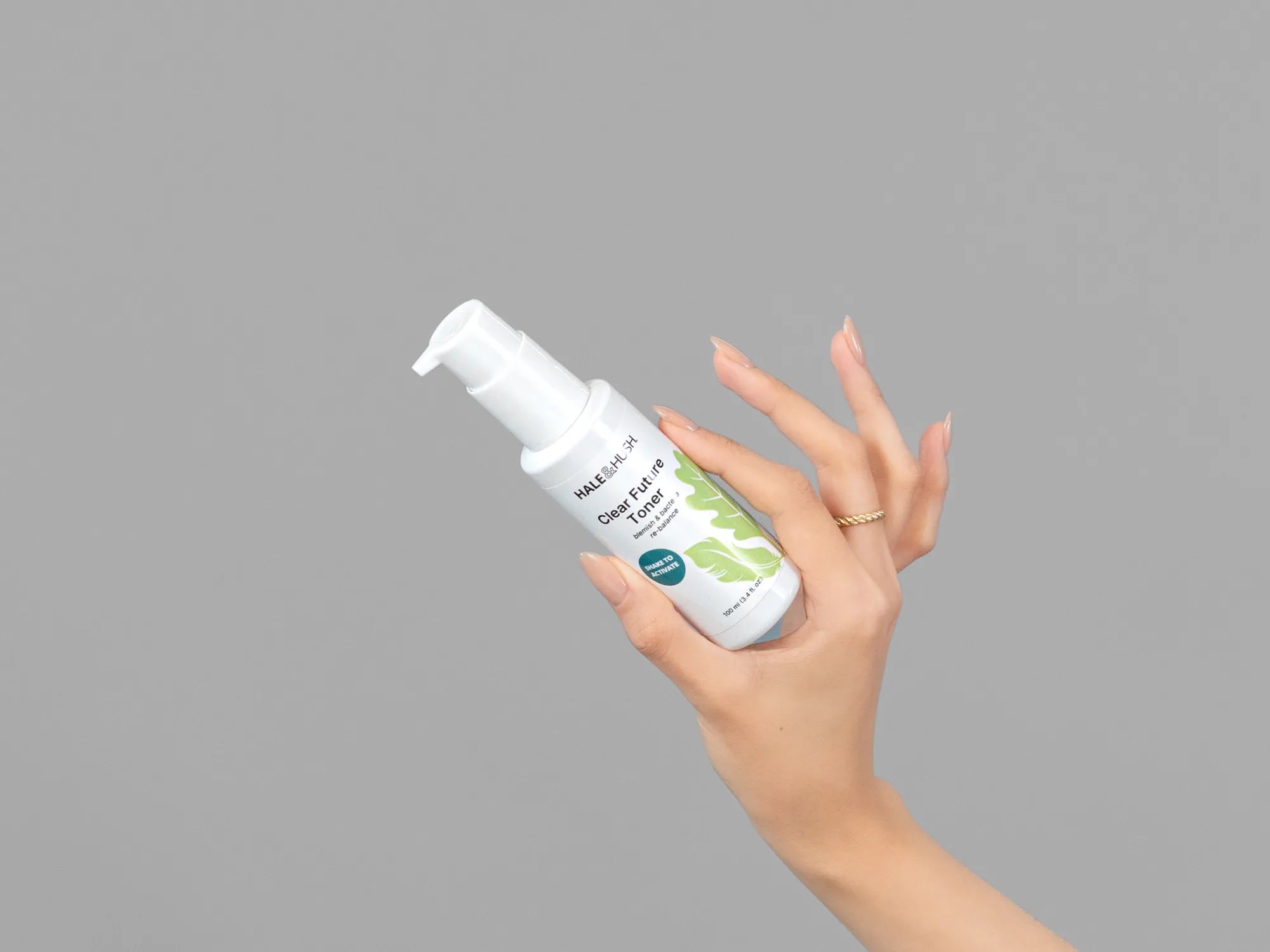 Closeup of Laziza from LAZ Skincare holding up a bottle of Hale & Hush Clear Future Toner