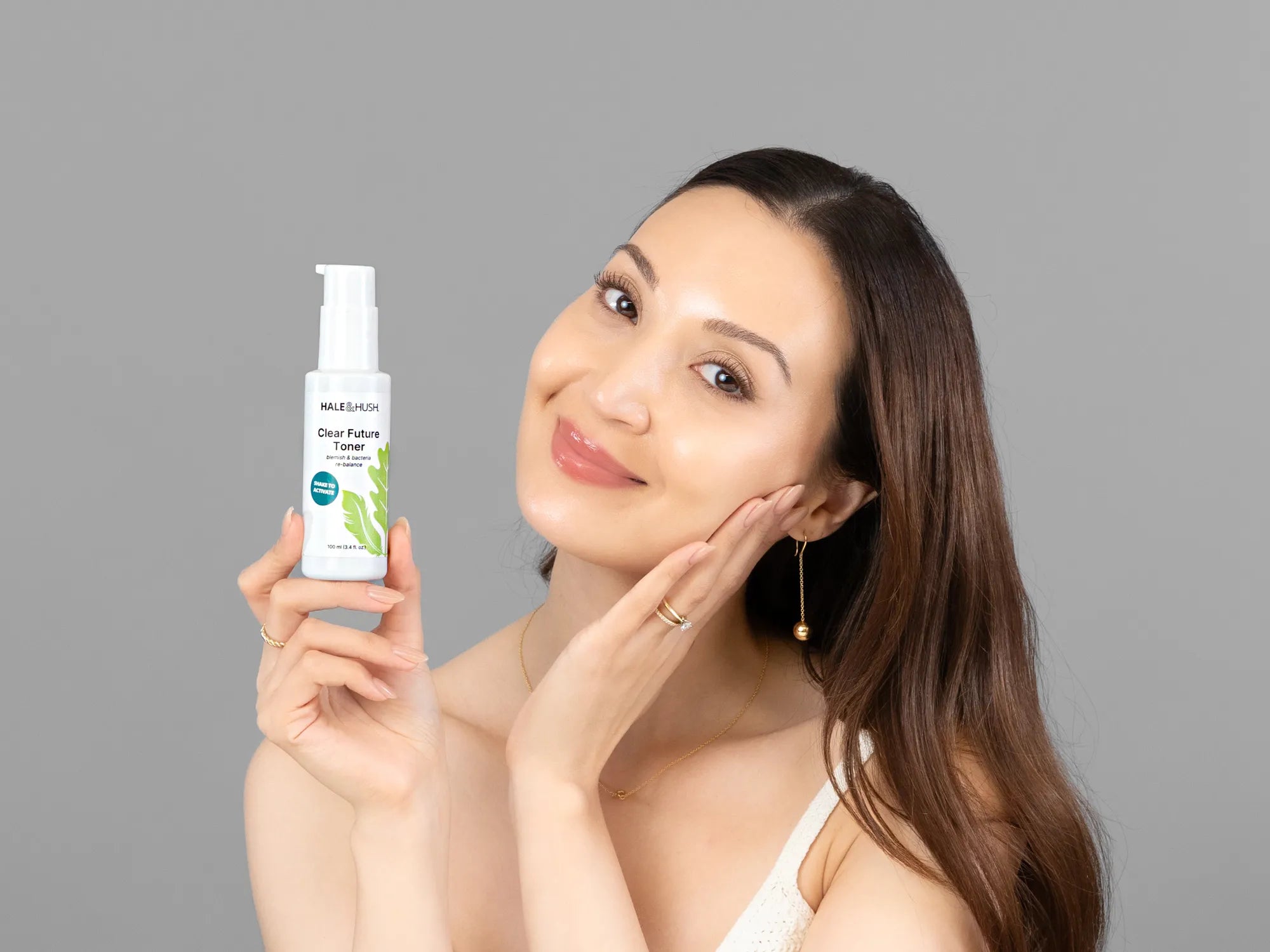 Laziza from LAZ Skincare holding a bottle of Hale & Hush Clear Future Toner up to her face