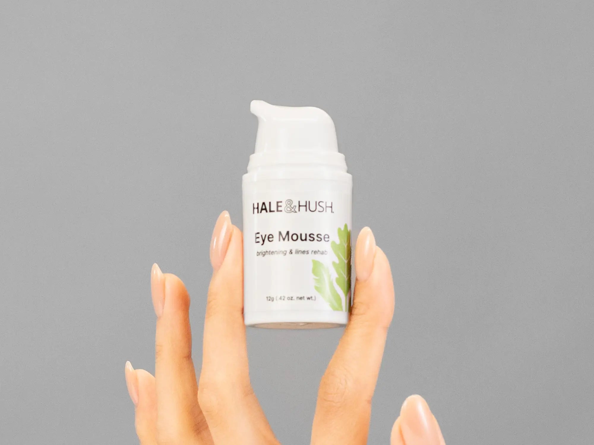 Closeup of Laziza from LAZ Skincare holding up a bottle of Hale & Hush Eye Mousse