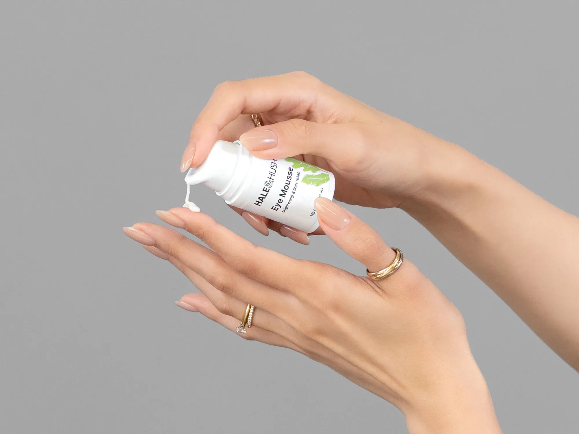 Closeup of Laziza from LAZ Skincare holding up a bottle of Hale & Hush Eye Mousse