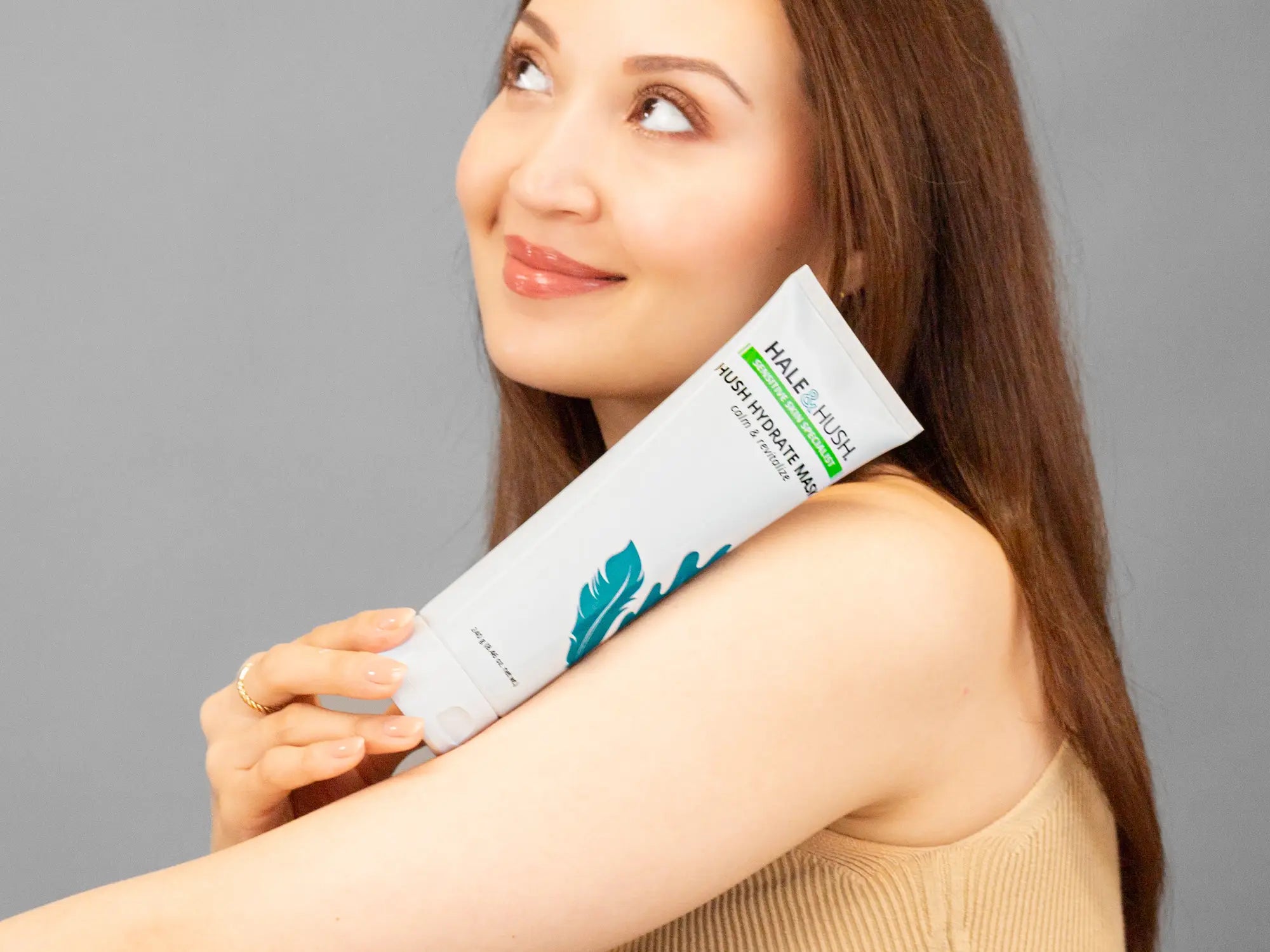 Laziza from LAZ Skincare holding a bottle of Hale & Hush Hush Hydrate Mask up to her face