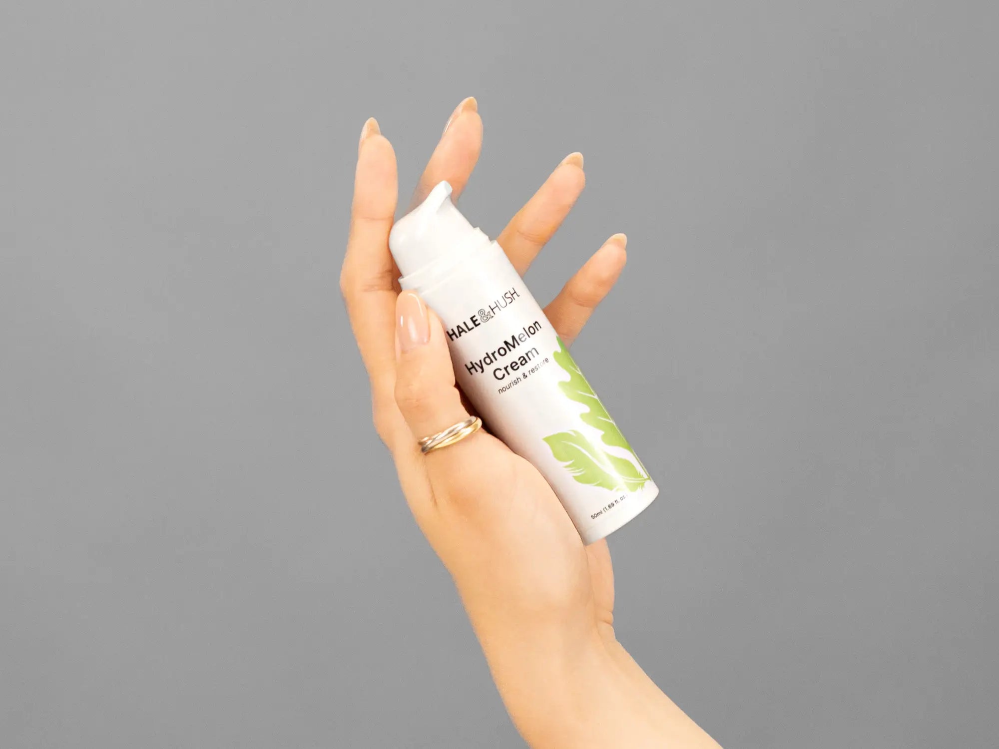 Closeup of Laziza from LAZ Skincare holding up a bottle of Hale & Hush HydroMelon Cream