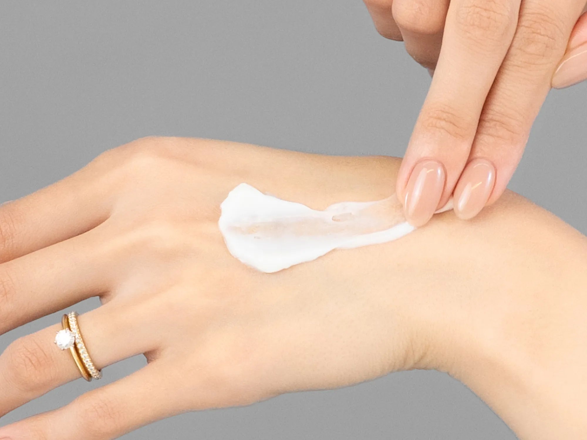 Laziza from LAZ Skincare demonstrating the texture and application of Hale & Hush HydroMelon Cream on her hand