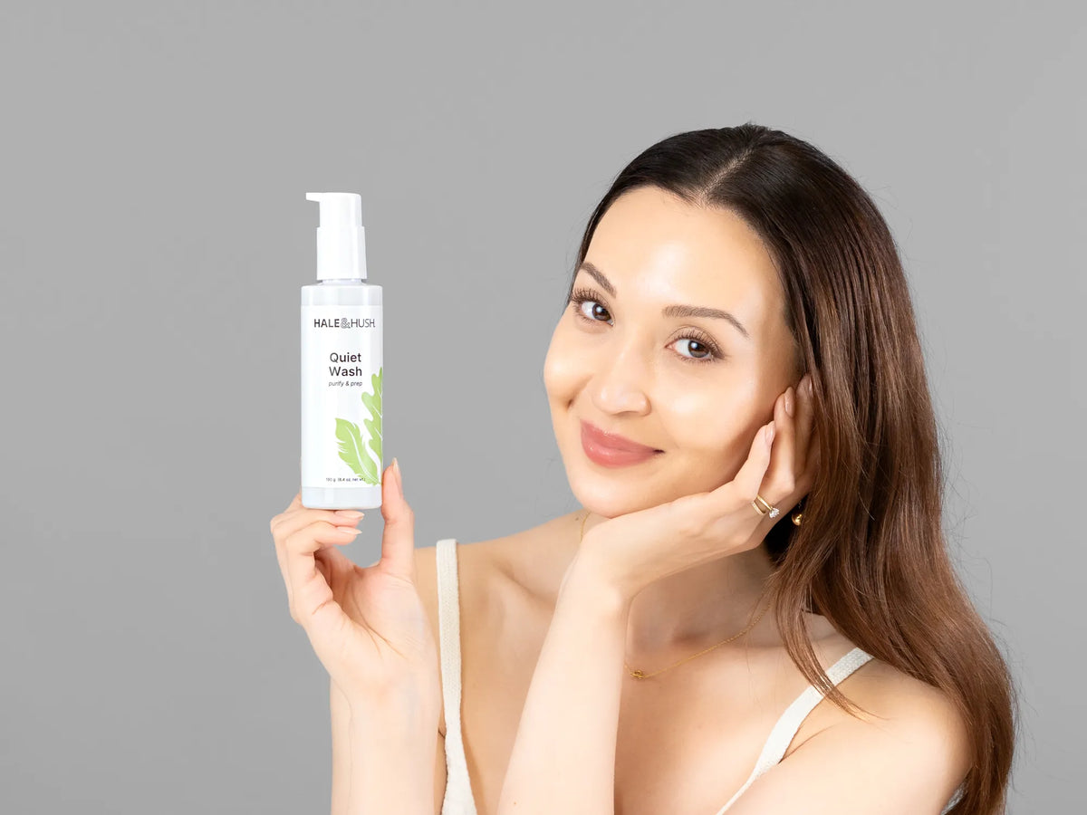 Laziza from LAZ Skincare holding a bottle of Hale & Hush Quiet Wash up to her face