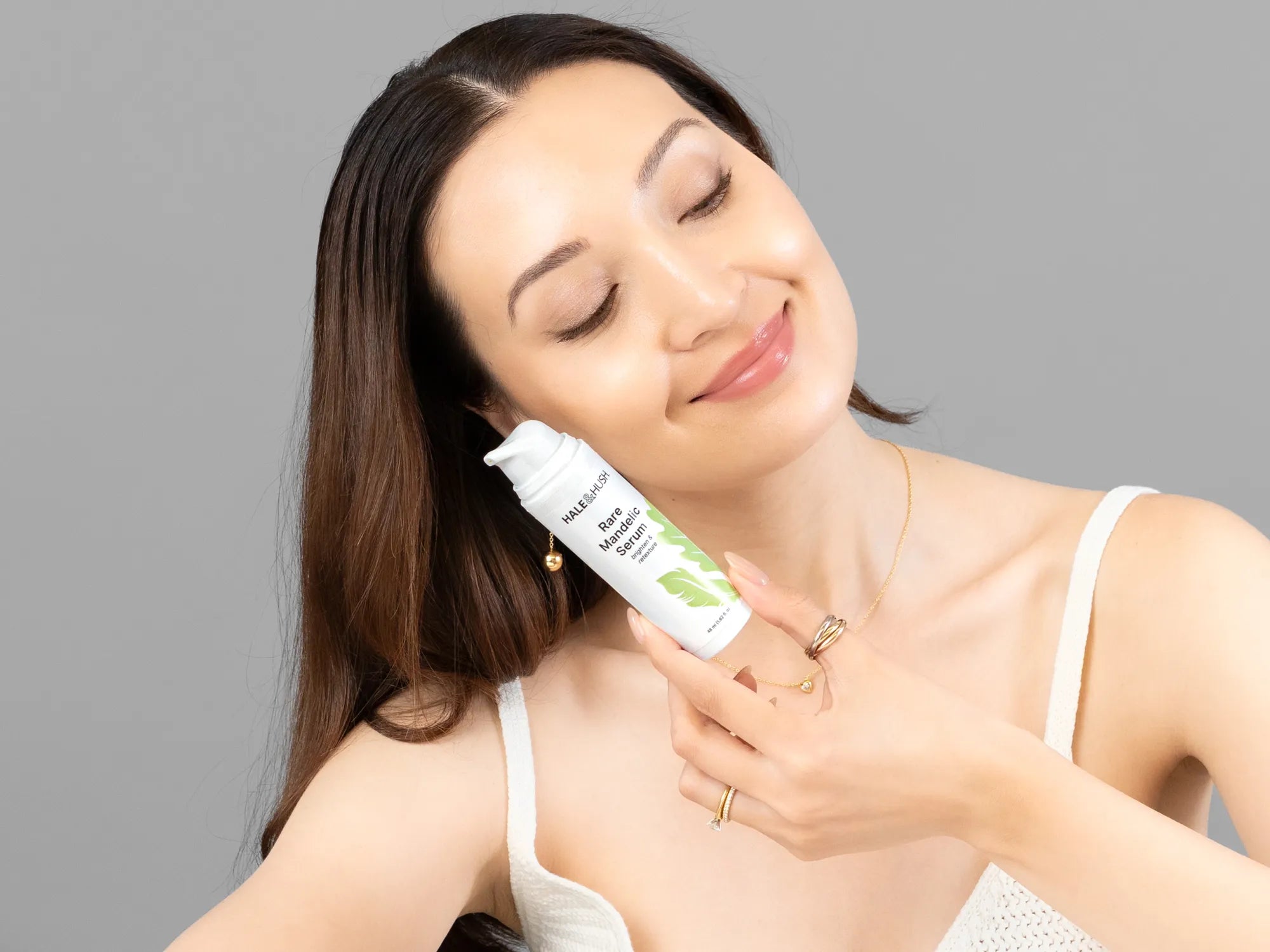 Laziza from LAZ Skincare holding a bottle of Hale & Hush Rare Mandelic Serum up to her face