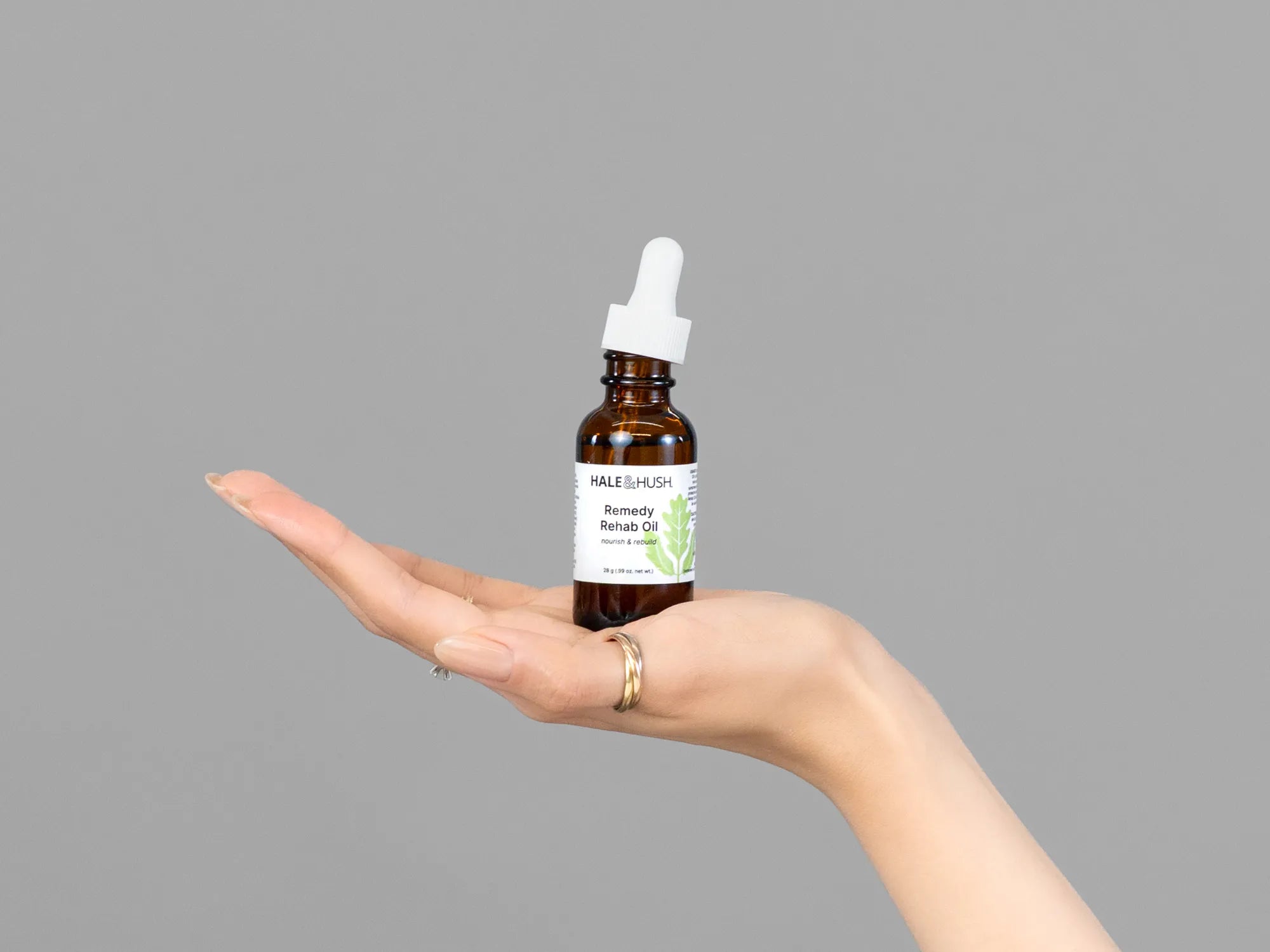 Closeup of Laziza from LAZ Skincare holding up a bottle of Hale & Hush Remedy Rehab Oil