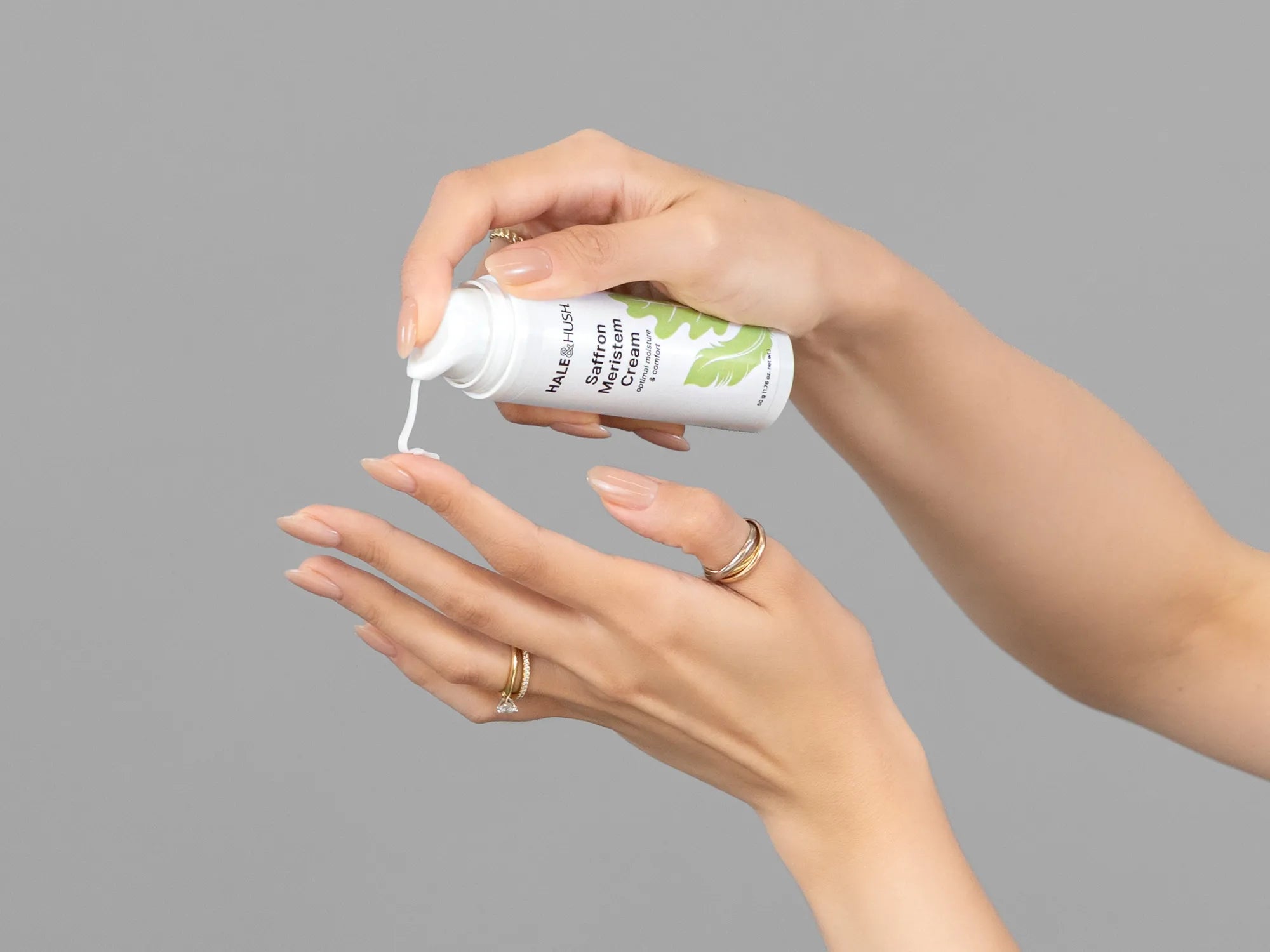Closeup of Laziza from LAZ Skincare holding up a bottle of Hale & Hush Saffron Meristem Cream