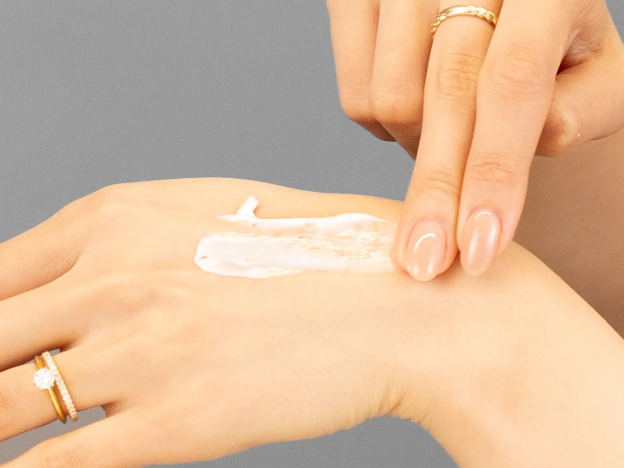 Laziza from LAZ Skincare demonstrating the texture and application of Hale & Hush Saffron Meristem Cream on her hand
