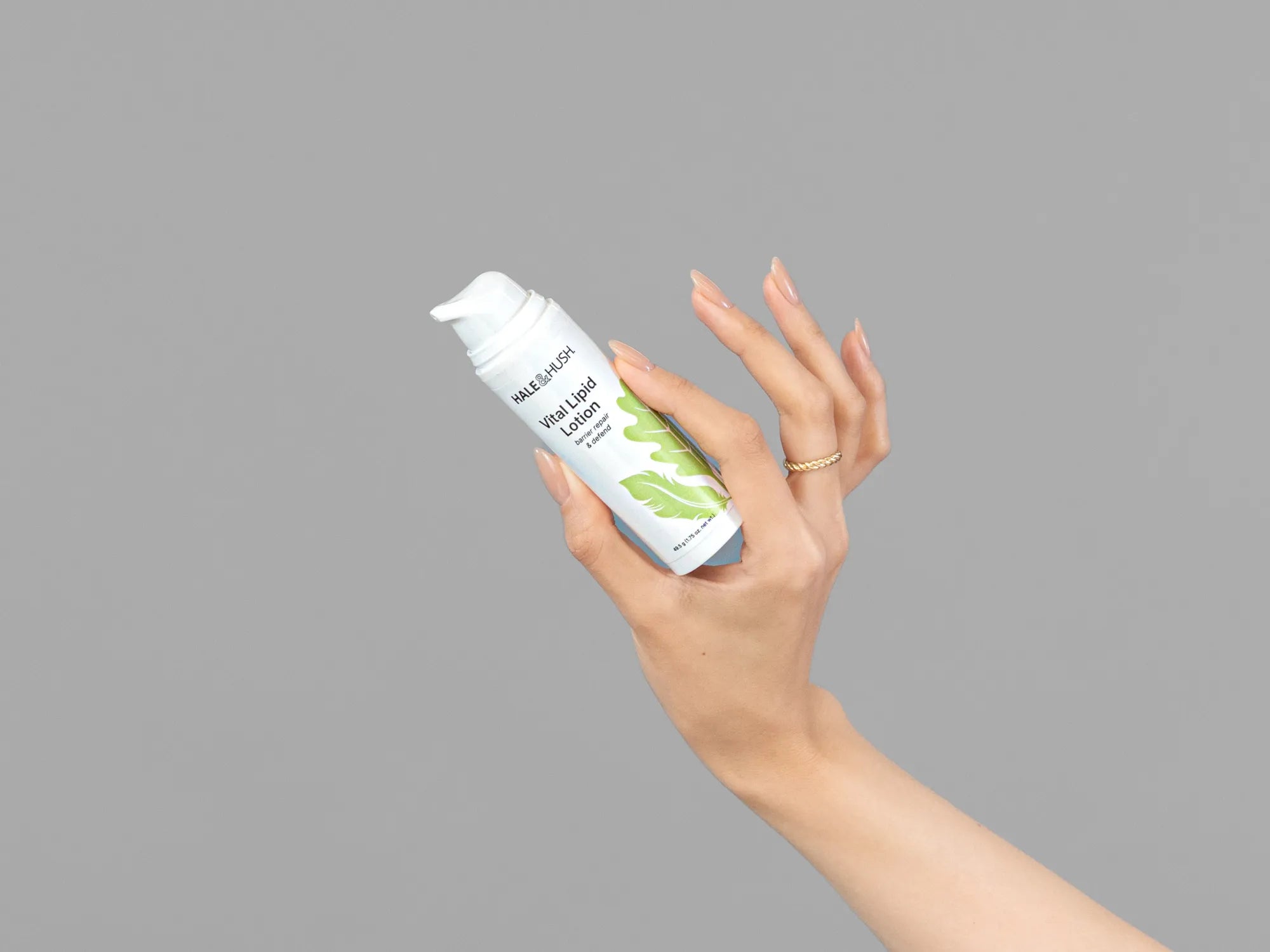 Closeup of Laziza from LAZ Skincare holding up a bottle of Hale & Hush Vital Lipid Lotion