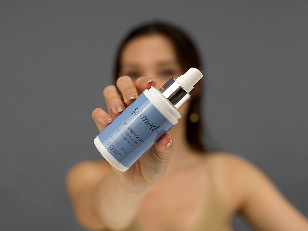 Laziza from LAZ Skincare demonstrating the texture and application of GlyMed Hemp Skin Mist on her hand