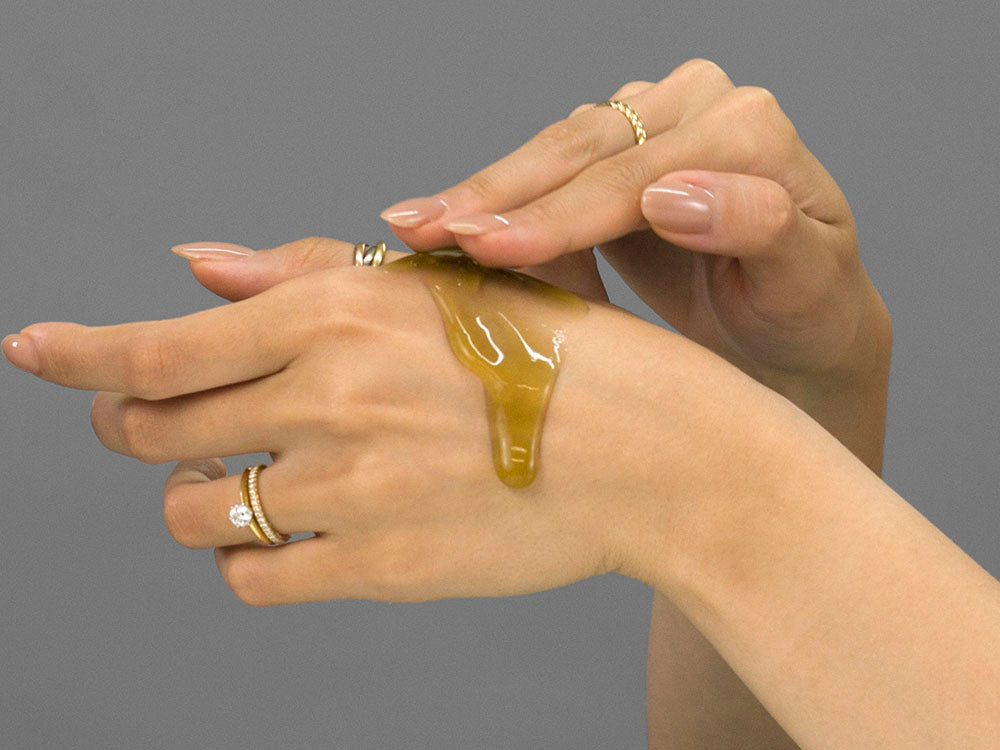 Laziza from LAZ Skincare demonstrating the texture and application of Face Reality HydraBalance Gel on her hand