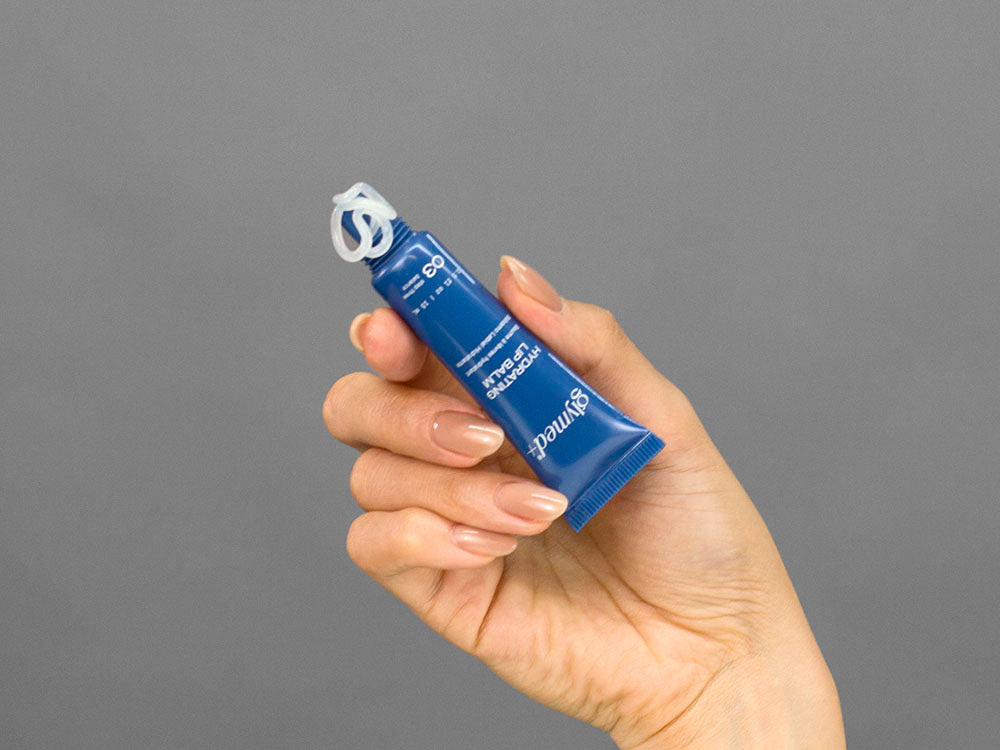 Closeup of Laziza from LAZ Skincare holding up a bottle of GlyMed Hydrating Lip Balm