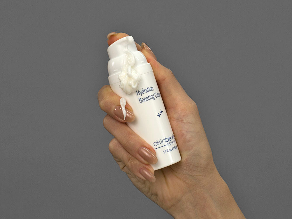 Closeup of Laziza from LAZ Skincare holding up a bottle of SkinBetter Science Hydration Boosting Cream