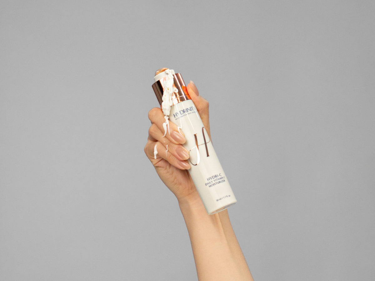 Closeup of Laziza from LAZ Skincare holding up a bottle of Hydrinity HYDRI-C Daily Vitamin C Moisturizer