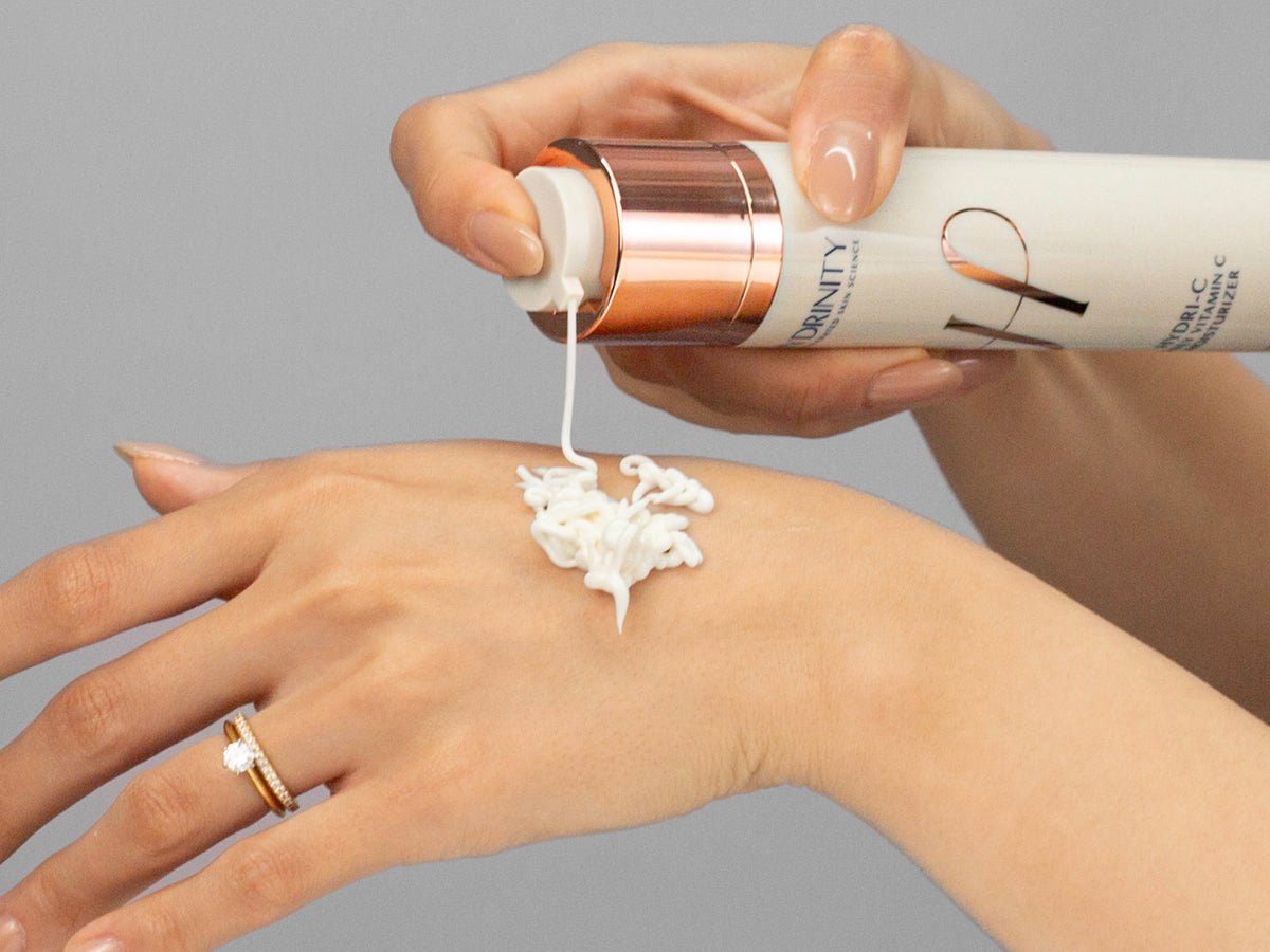 Laziza from LAZ Skincare demonstrating the texture and application of Hydrinity HYDRI-C Daily Vitamin C Moisturizer on her hand