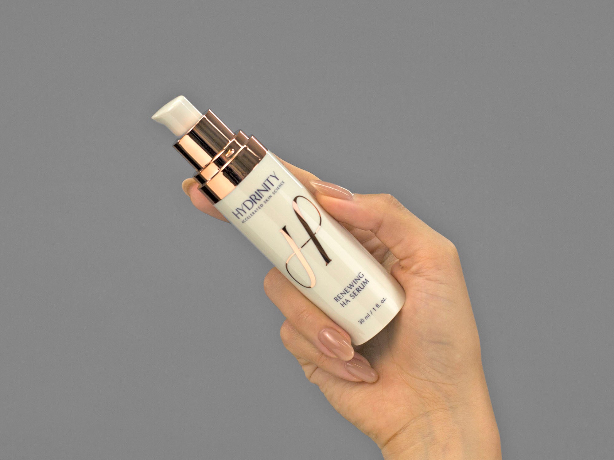 Closeup of Laziza from LAZ Skincare holding a bottle of Hydrinity Renewing HA Serum in her hand