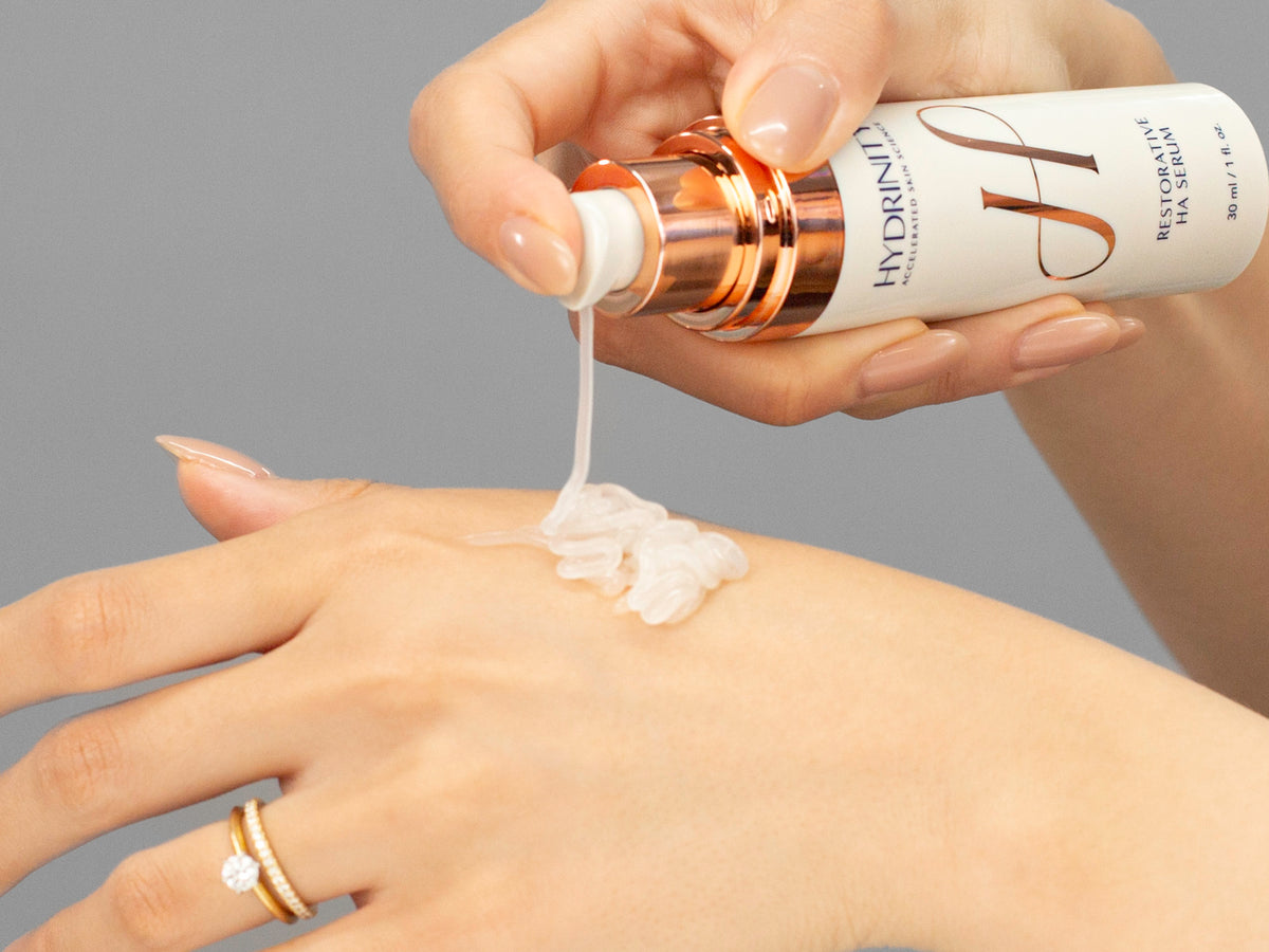 Laziza from LAZ Skincare demonstrating the texture and application of Hydrinity Restorative HA Serum on her hand