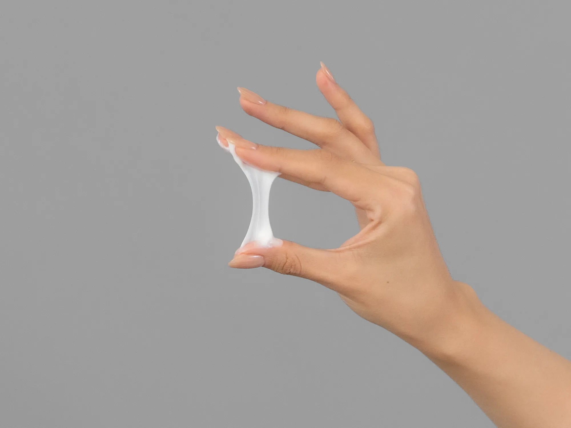Laziza from LAZ Skincare demonstrating the texture and application of KrX Aesthetics Neck Lift Intensive Firming Cream on her hand