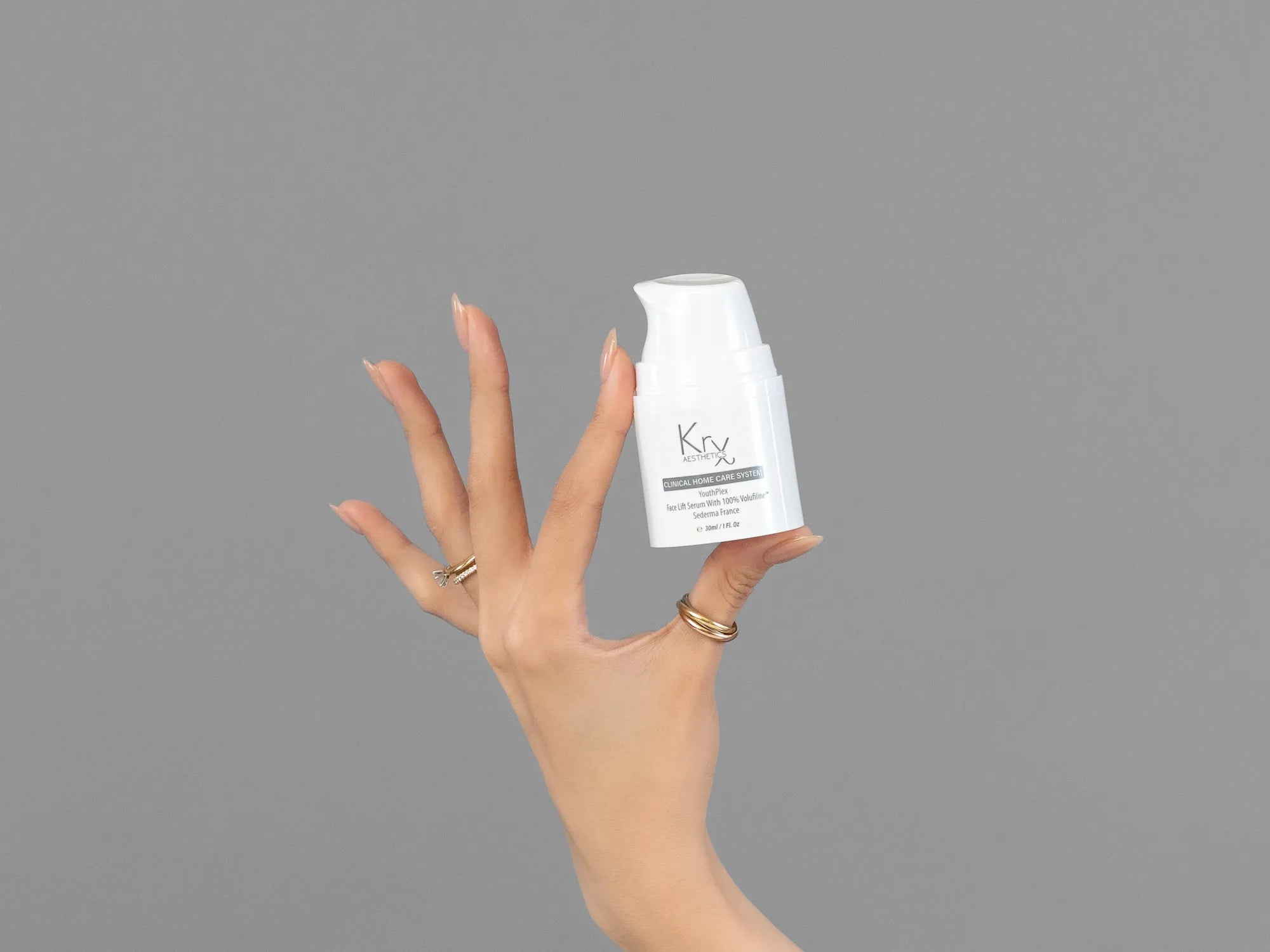 Closeup of Laziza from LAZ Skincare holding up a bottle of KrX Aesthetics Youthplex Face Lift Serum